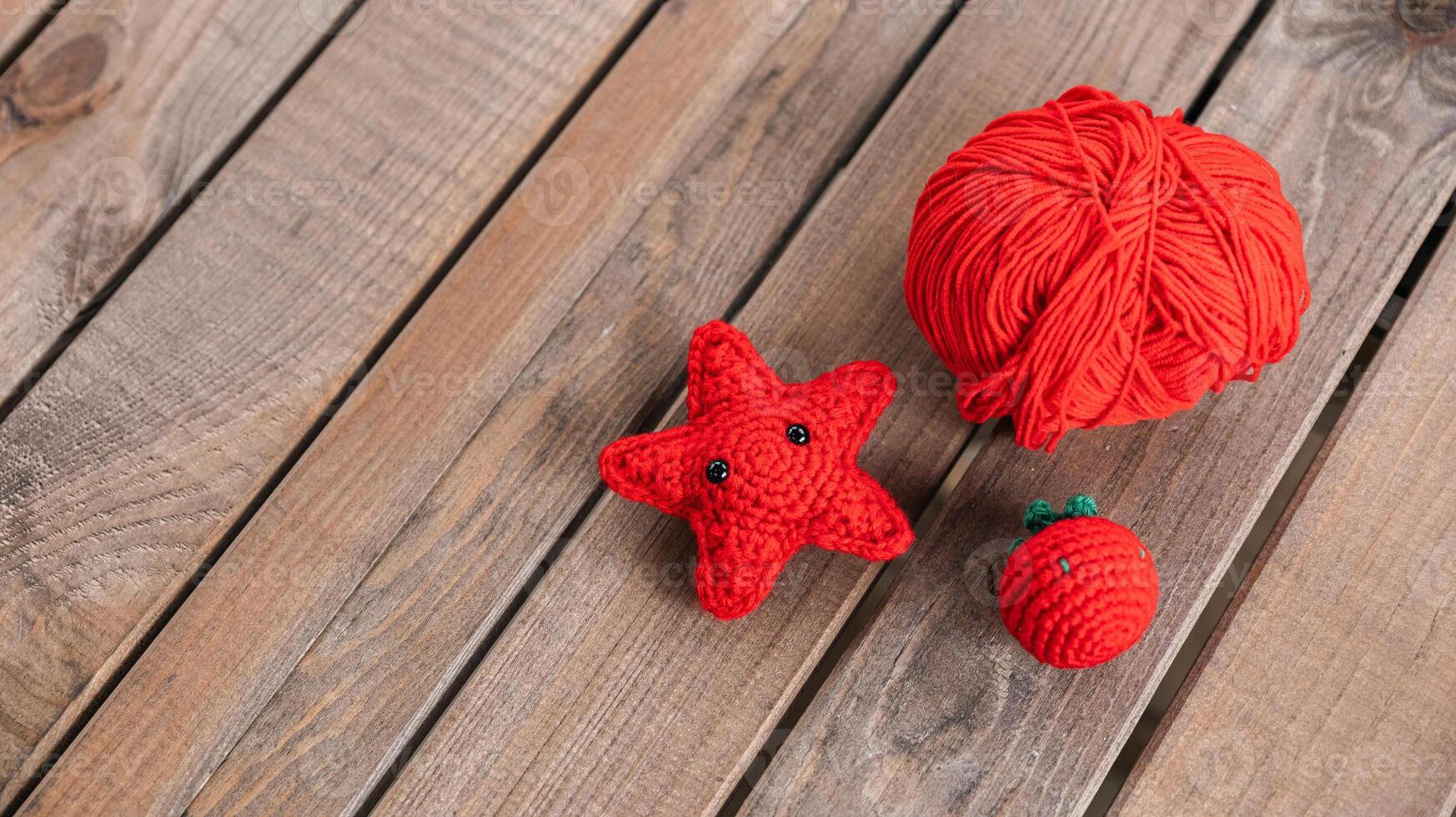 Ball of bright red yarn and two cute crocheted items a starfish. photo