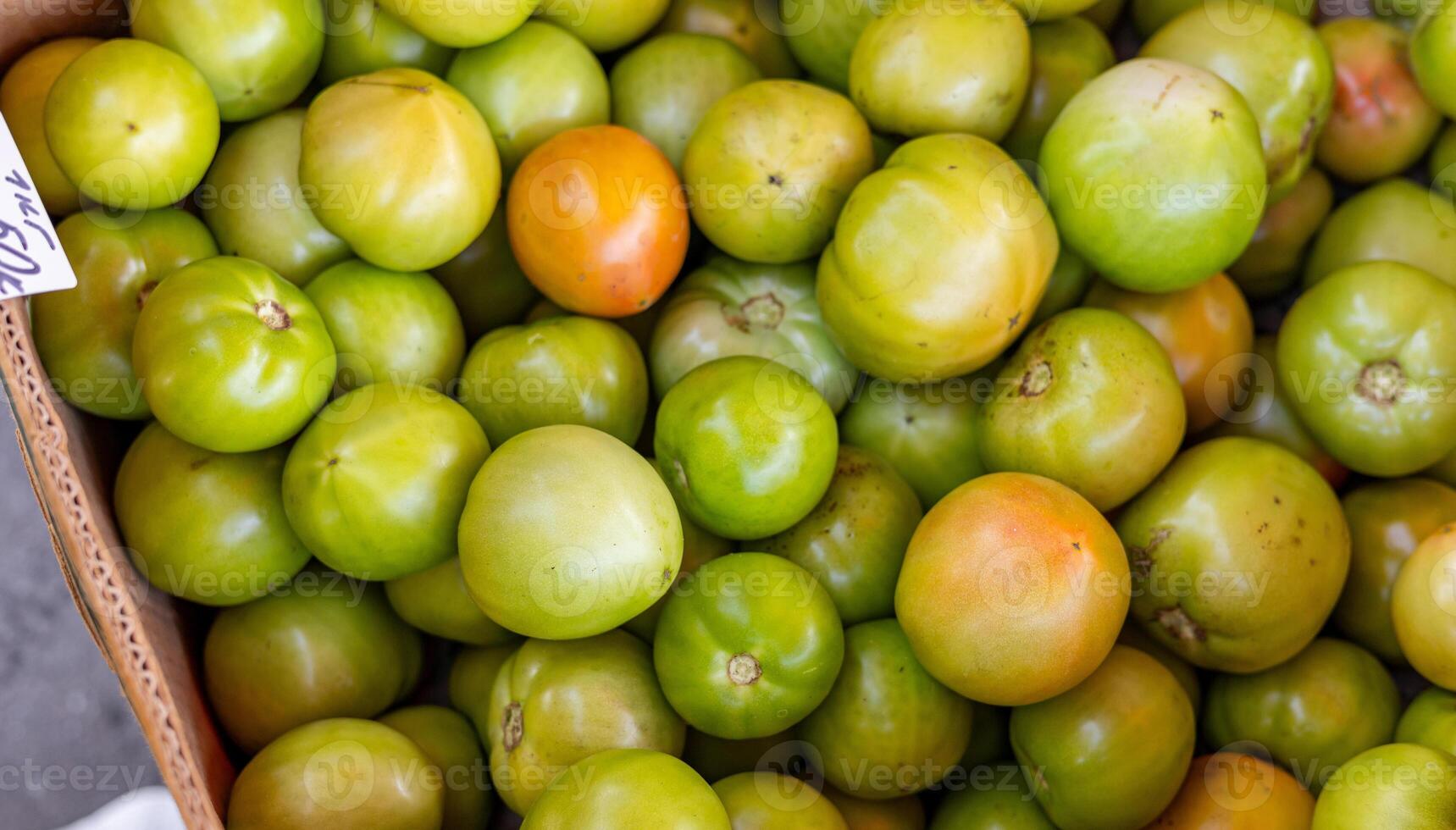 In the home garden, three large, fleshy and very juicy green tomatoes lie on a stump. Organic, fresh produce is sold at the local farmers market. Concept of gardening and agriculture. selective focus photo