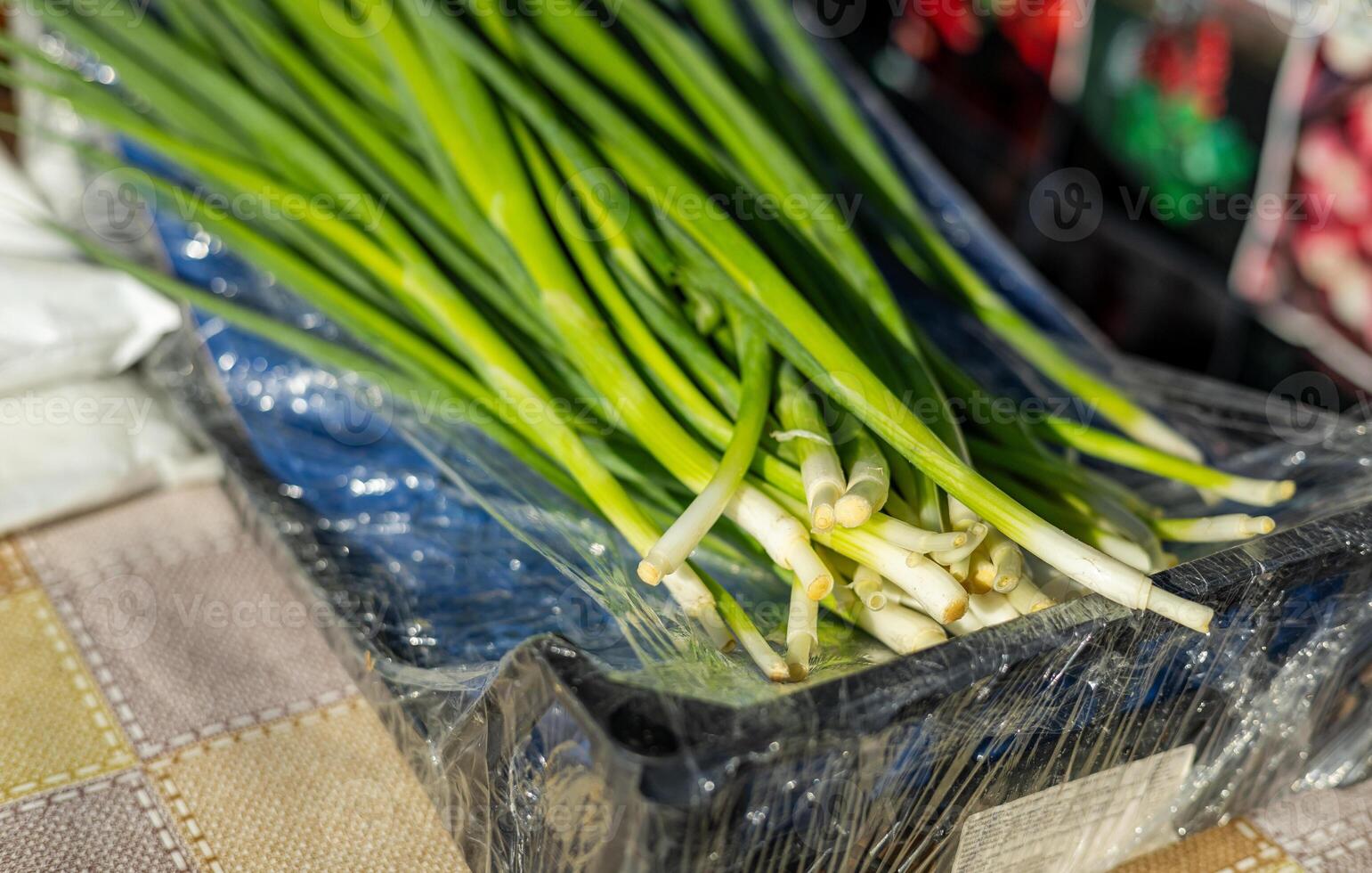 Leeks arranged in large piles on the display at the farmer's market. Green leafy leek. A pattern of green stems. photo