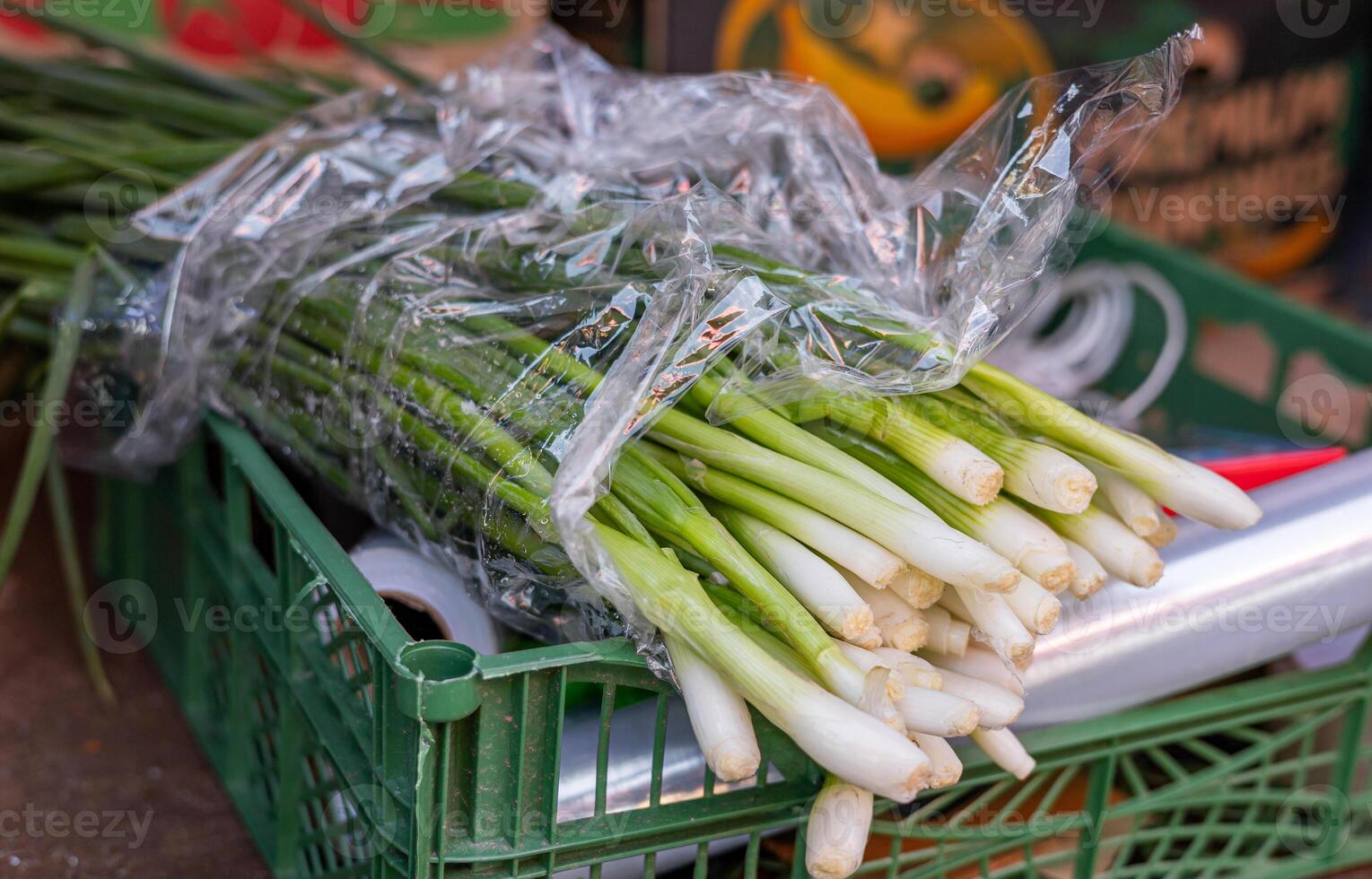 Leeks arranged in large piles on the display at the farmer's market. Green leafy leek. A pattern of green stems. photo