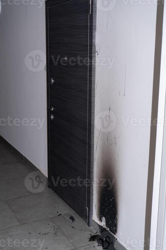 Arson of the front door of the apartment. Consequences of the fire. Black soot on the wall. photo