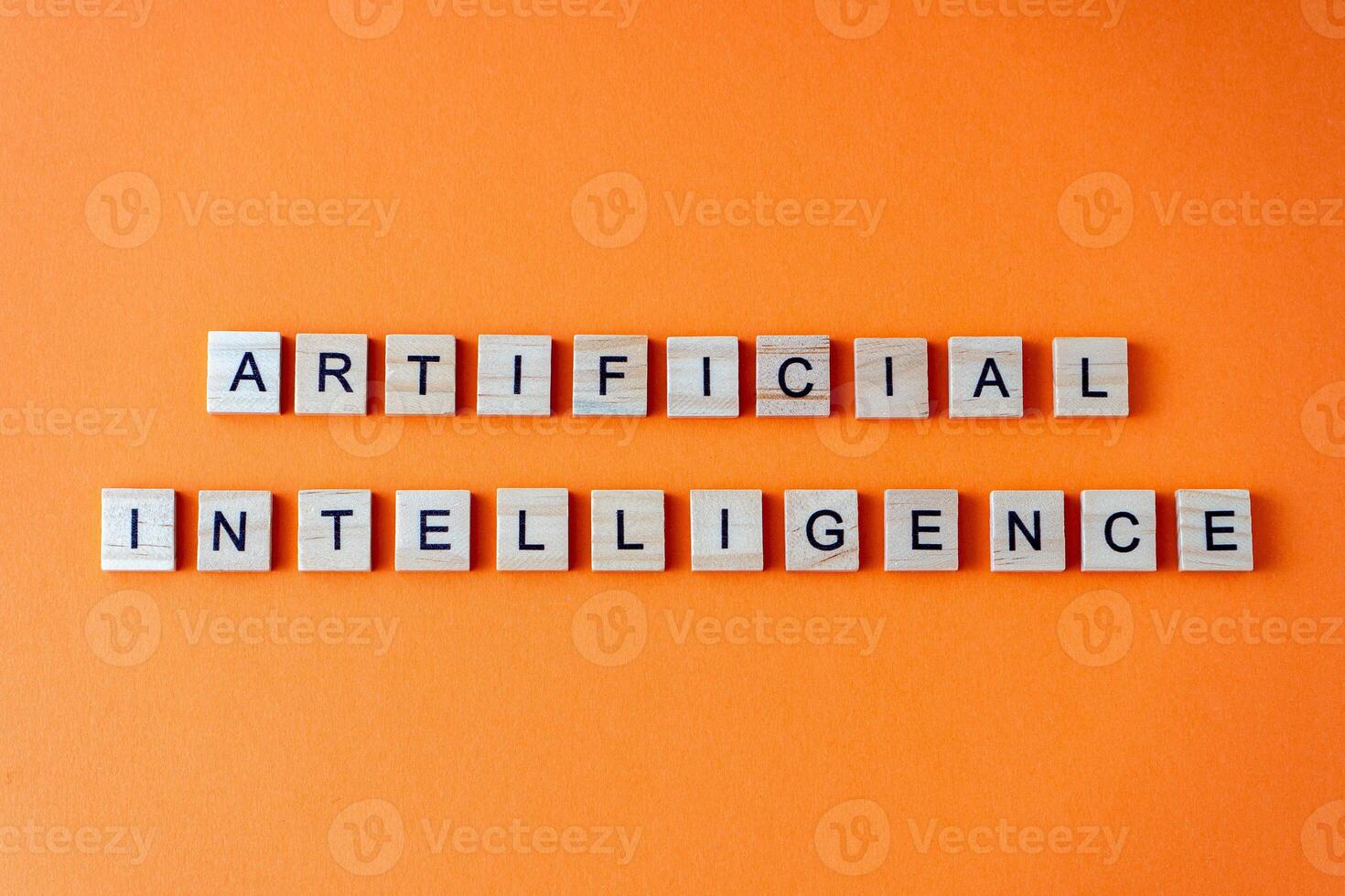 Word artificial intelligence. The phrase AI is laid out in wooden letters top view. Orange flat lay background. photo