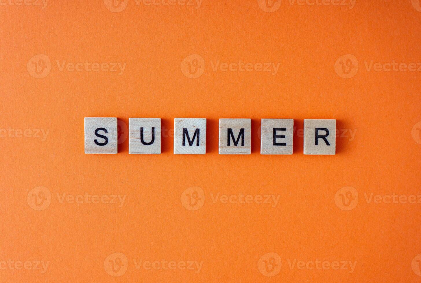 Summer word. The phrase is laid out in wooden letters top view. Motivation. Orange flat lay background. photo