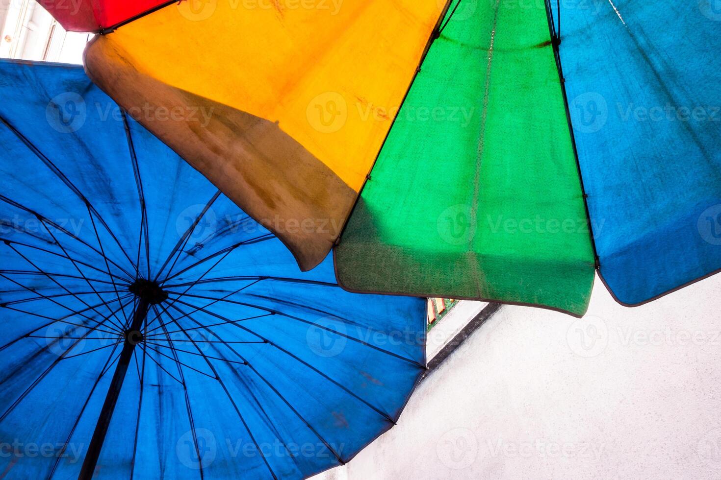 Vivid multi-colored on the old and dirty beach umbrella photo