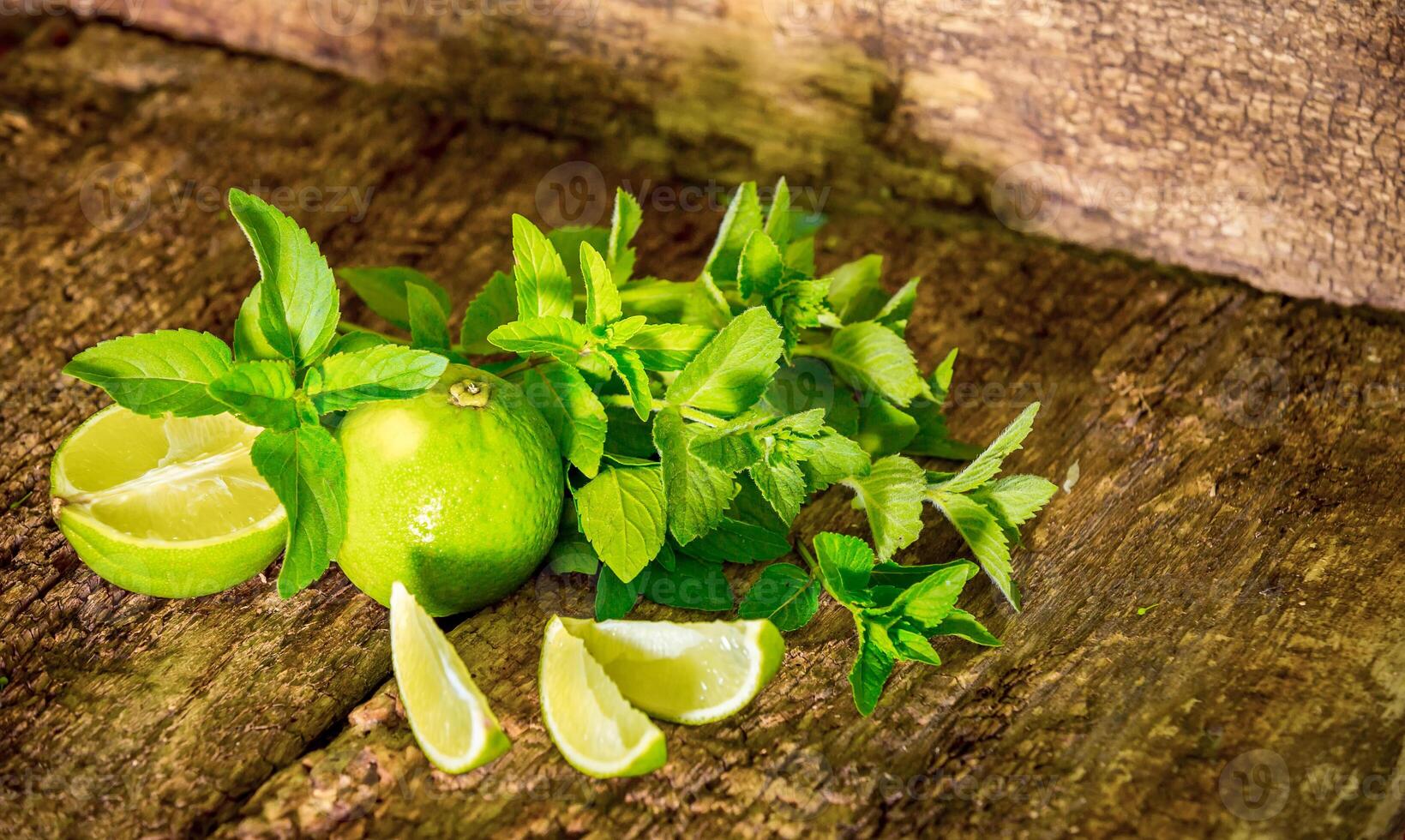 Lime with mint close up on wooden background. Mojito. Fresh citrus fruits. photo