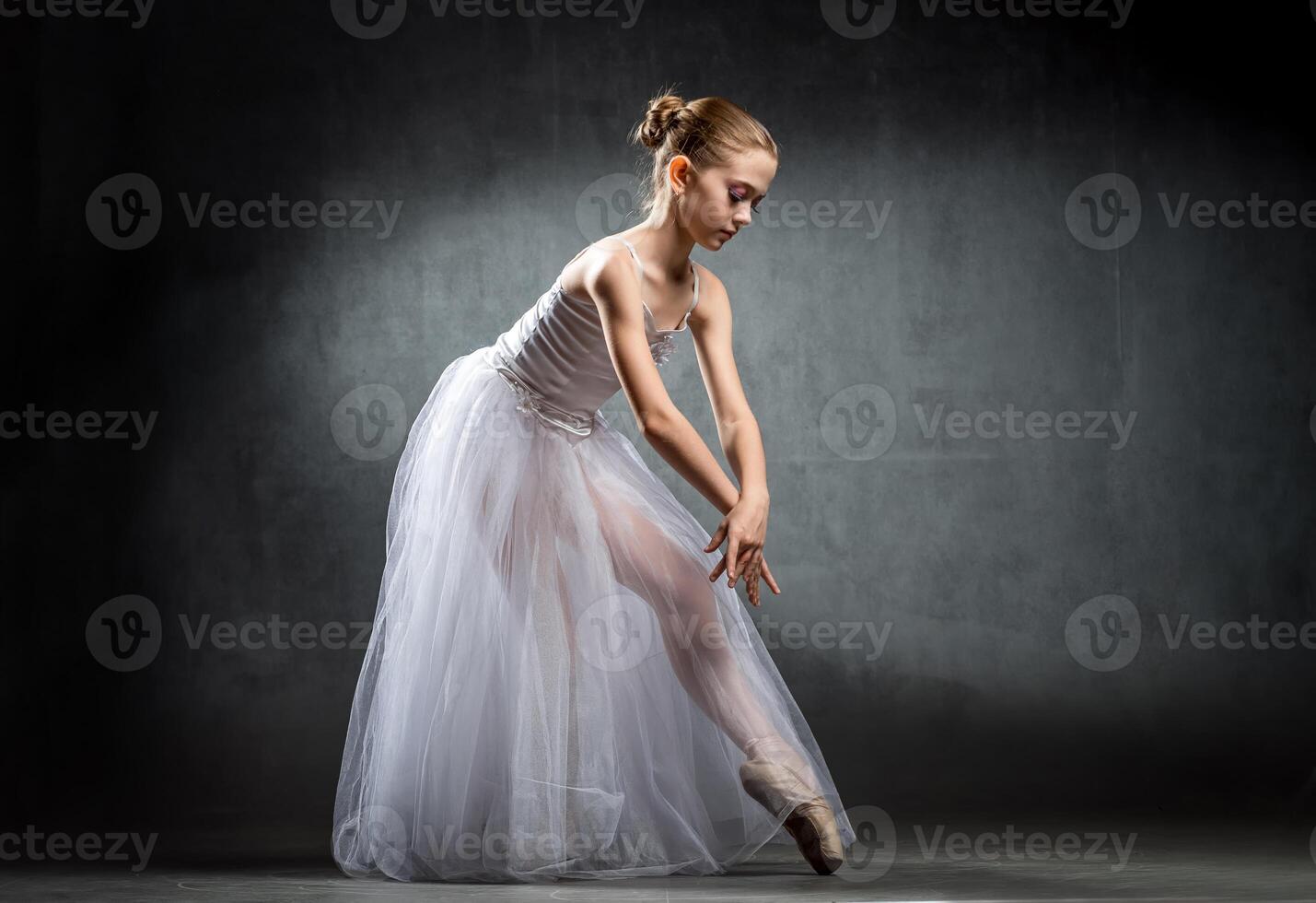 Ballet. Image of a flexible cute ballerina dancing in the studio. Beautiful young dancer. A ballerina is posing. photo