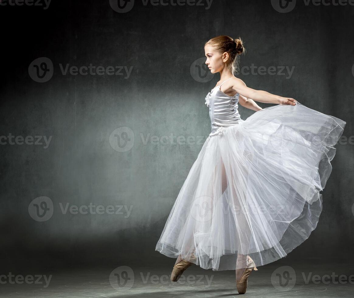 Ballet. Image of a flexible cute ballerina dancing in the studio. Beautiful young dancer. A ballerina is posing. photo