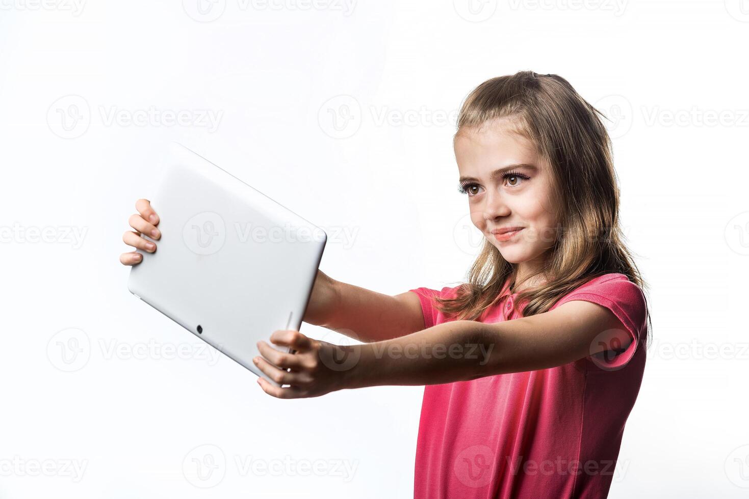 Little girl with a tablet computer on a white background. Emotions of the child. photo