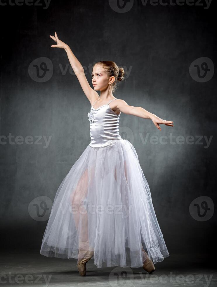 Ballet. Image of a flexible cute ballerina dancing in the studio. Beautiful young dancer. A ballerina is posing. photo