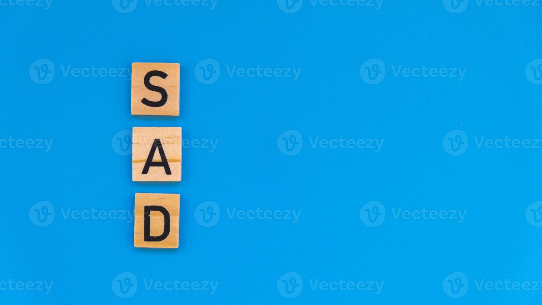 Seasonal affective disorder - text of wooden blocks on blue bright background. Concept of depression mood stress and anxiety. SAD wellbeing photo