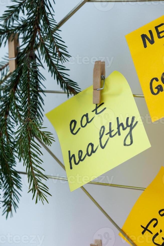 EAT HEALTHY goal on Vision board with new year resolutions aims on sticky notes. Preparation for New Year. Concept of planning and setting goals for personal development photo