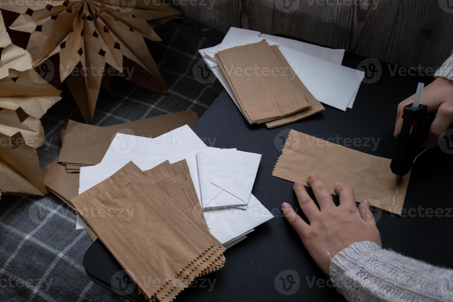 Process of using hot glue preparing for Christmas star and New Year eve. 3D craft bag snowflakes DIY. Responsible ecological zero waste handmade decoration. Children hobby activity Home decor photo