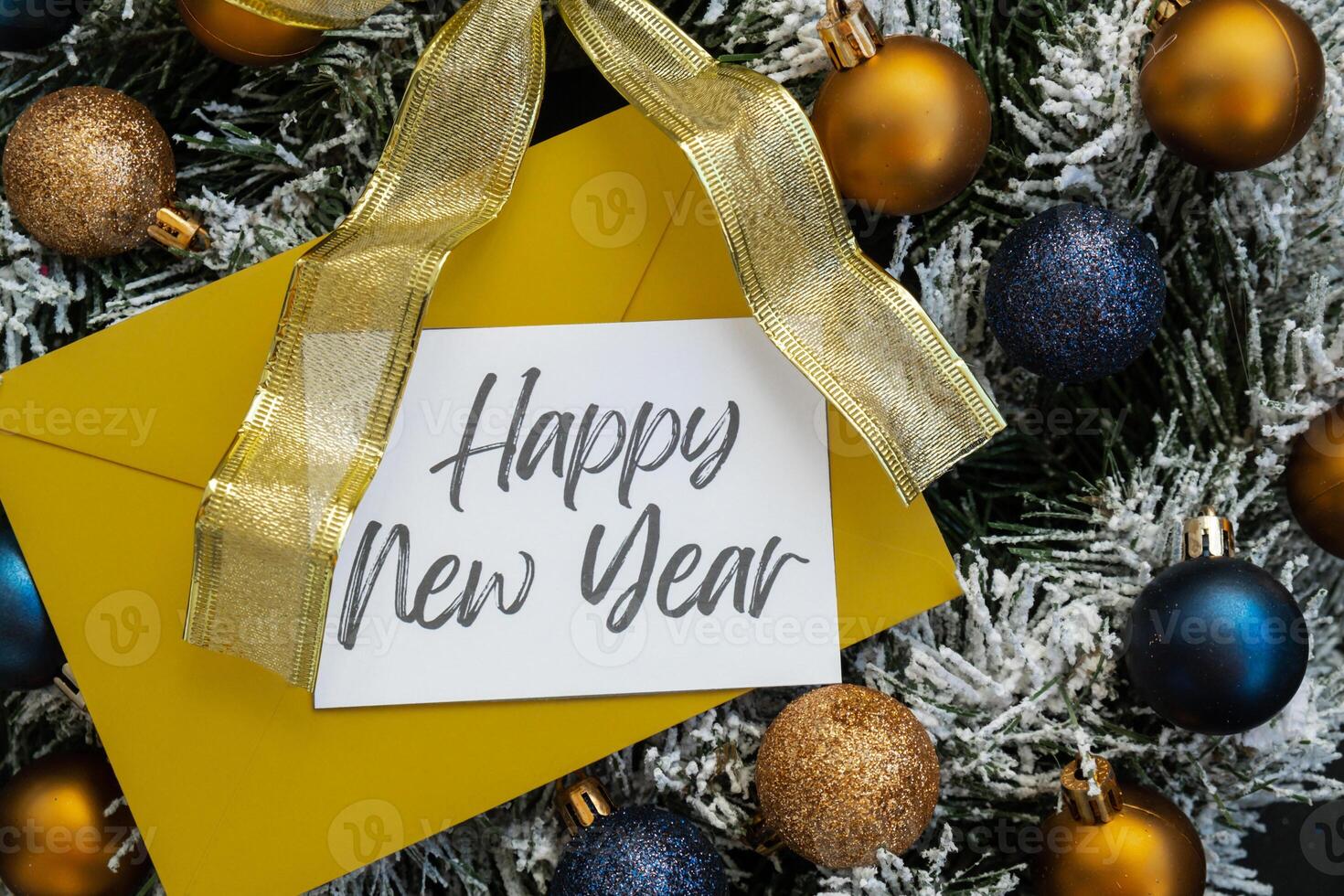 HAPPY NEW YEAR text on postcard with yellow envelope on handmade Christmas wreath. Zero waste eco-friendly Christmas. Sustainable greeting card decoration photo
