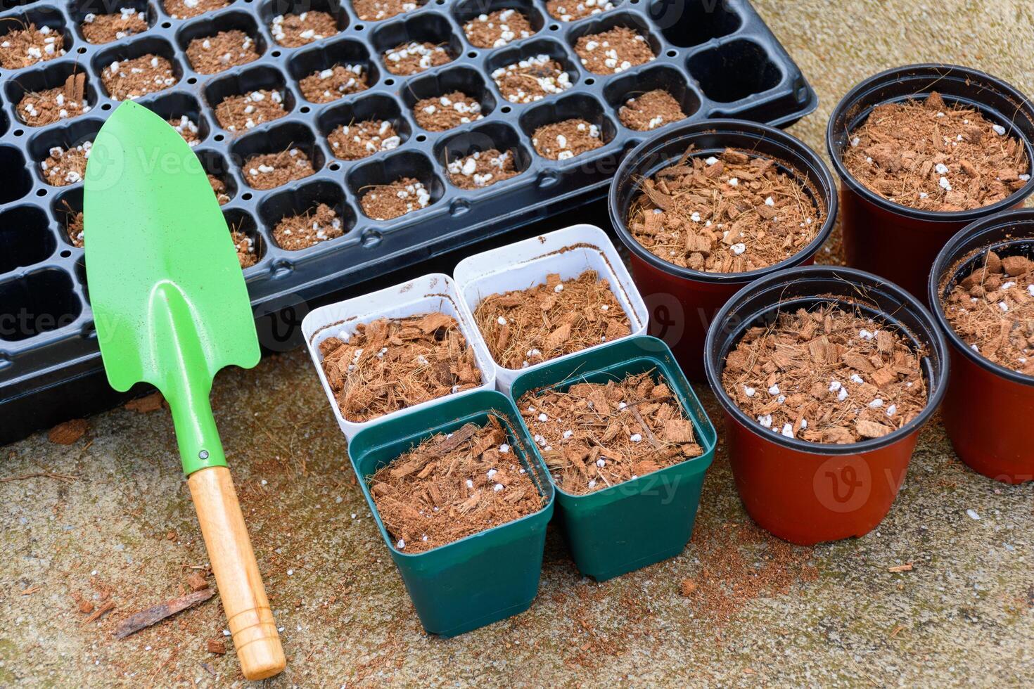 Green shovel and soil fertilizer in a pot for planting is preparing fertilizer for agricultural planting. Agricultural equipment for cultivation and nursery, peat moss, coco husk chips. photo