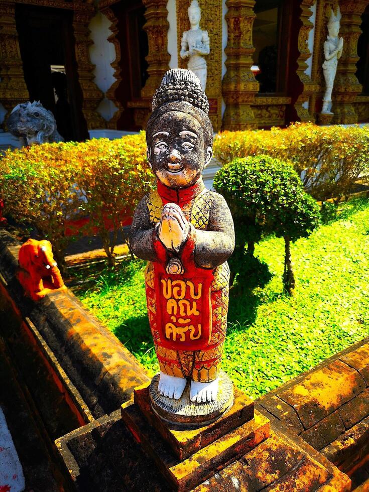 An old weathered statue of a little lady with prayer hands, Nimman, Chiang Mai, Thailand, 2024. photo