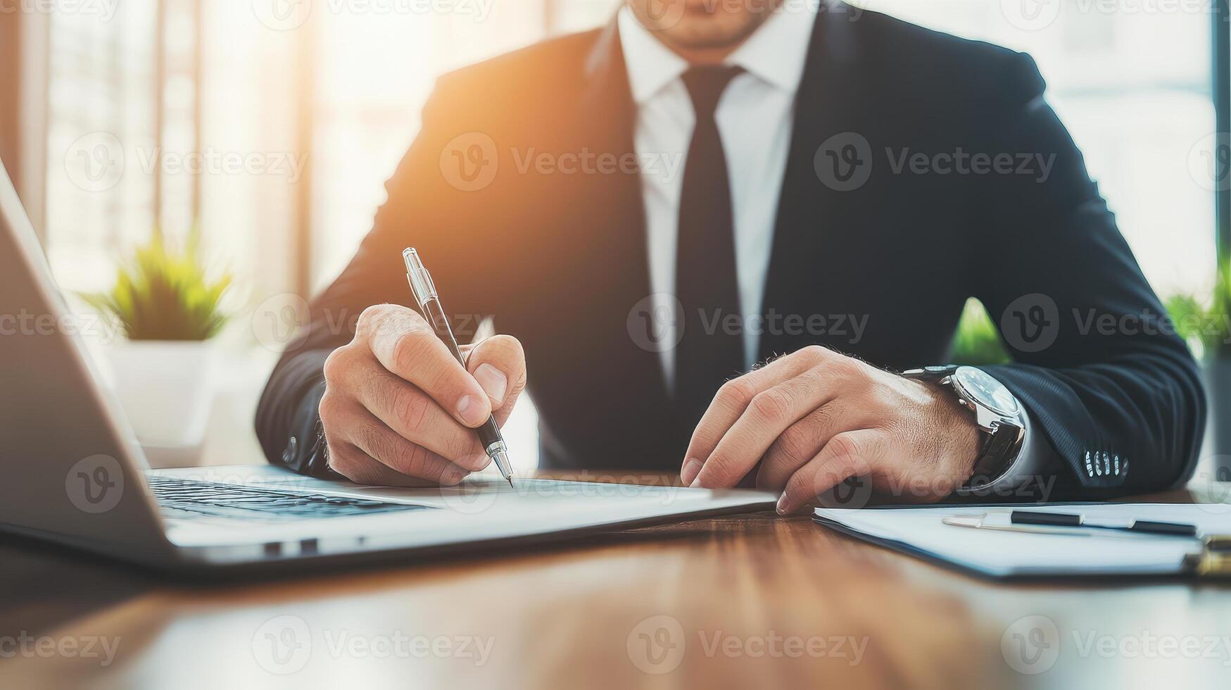 A focused businessman takes notes at his home office desk, capturing essential details for effective planning and strategy. photo