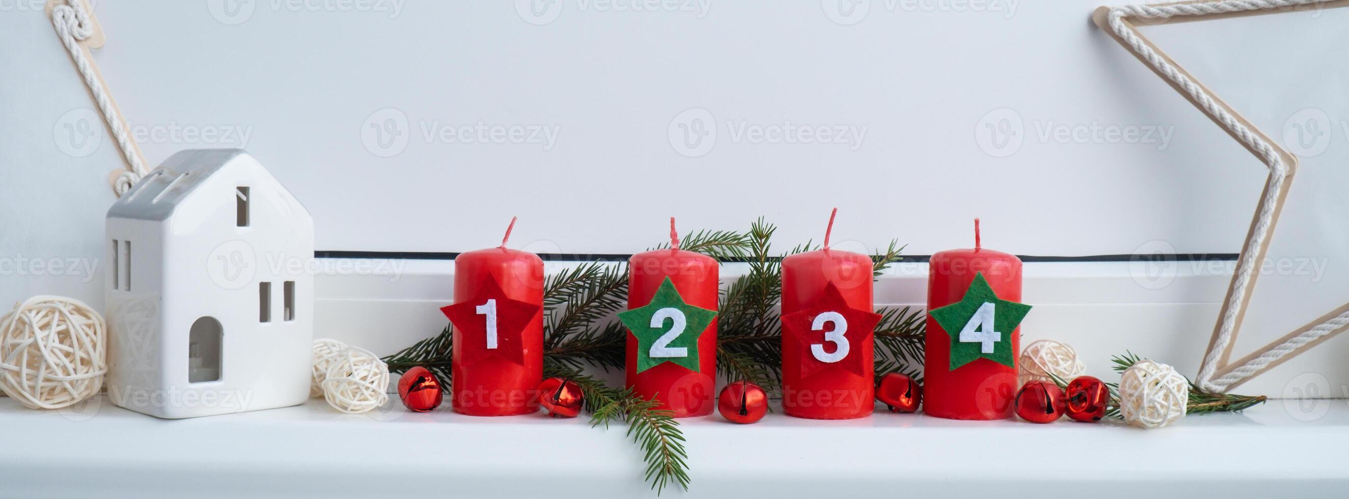 Four Advent red candles with numbers, fir branches and Christmas zero waste decorations in windowsill. Holiday preparation copy space for text. Catholic traditions of Christmas new year winter holidays photo