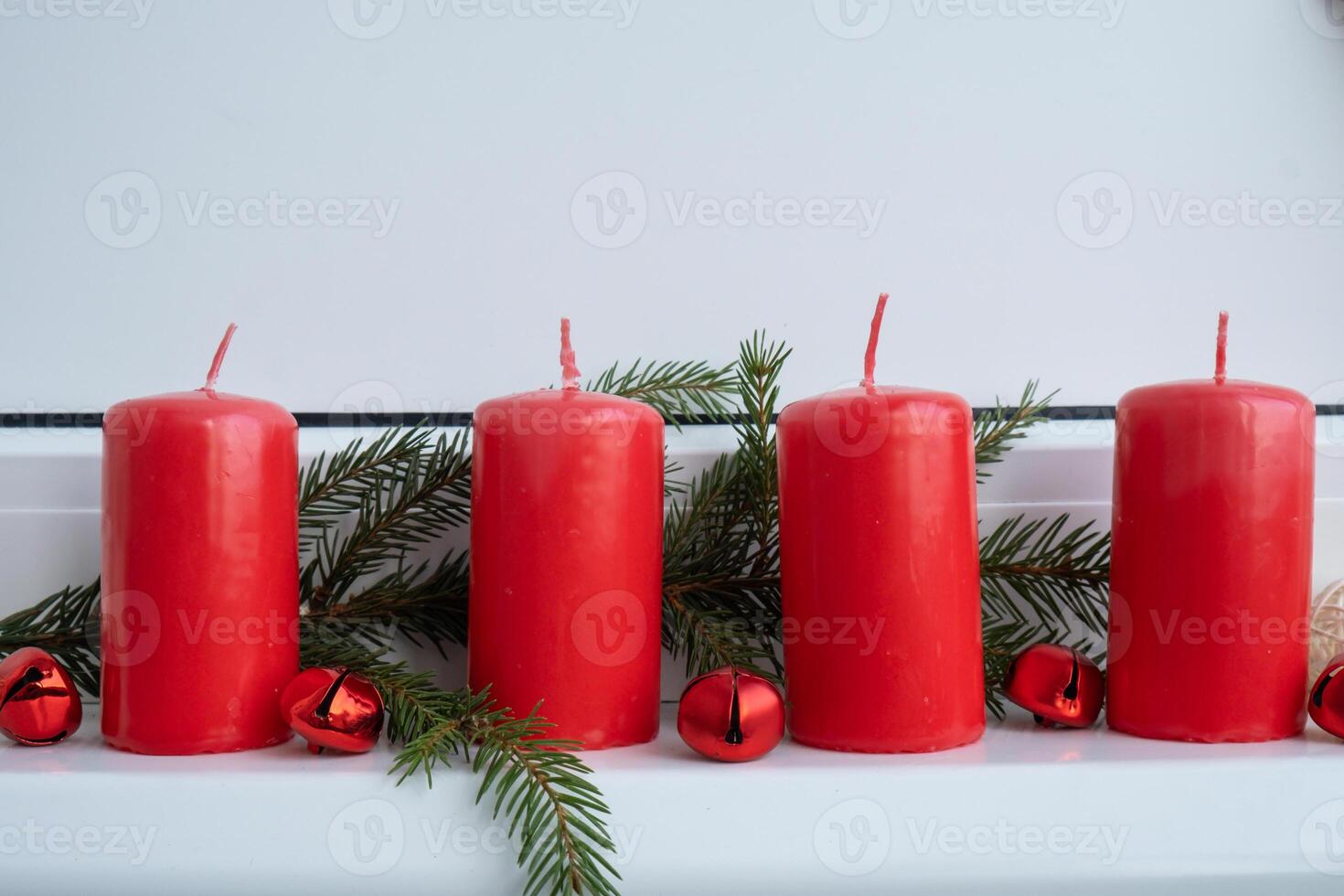 New year and Christmas preparation. Four red advent candles in white windowsill. Handmade eco-friendly decor. Sustainable Christmas decoration. Copy space photo