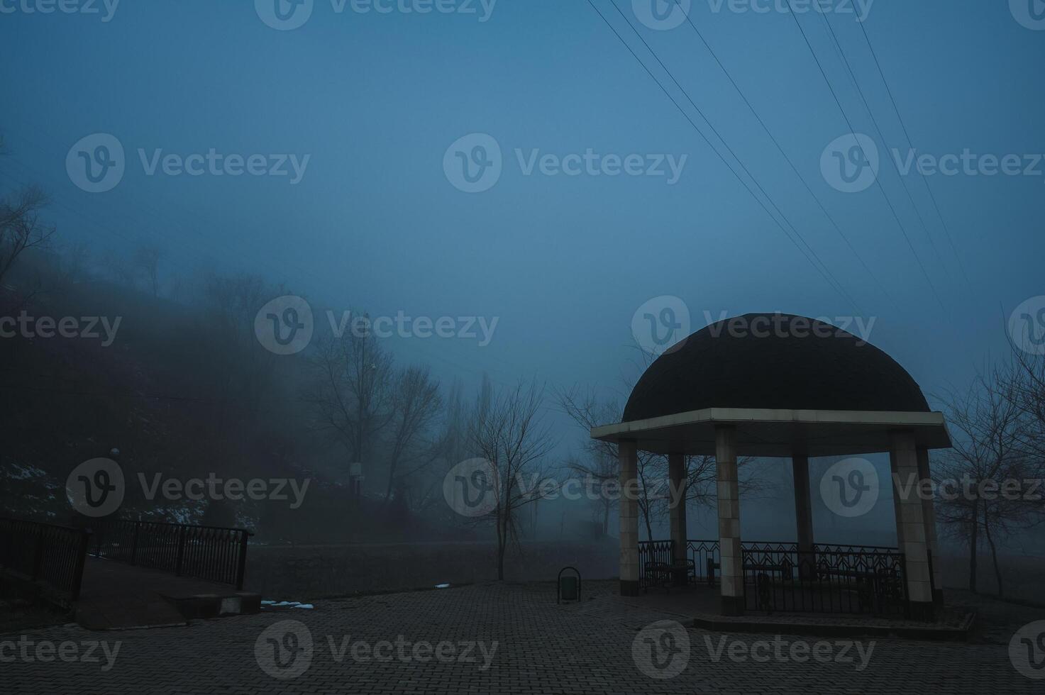 misty landscape with a gazebo by river on an autumn morning in the fog mist photo