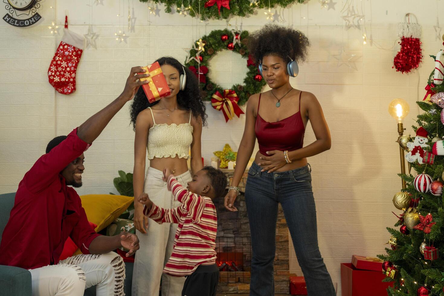 A family joyfully decorates a Christmas tree, hanging ornaments and festive decorations.The family members are engaged in adding the final touches to their beautiful Christmas tree. photo