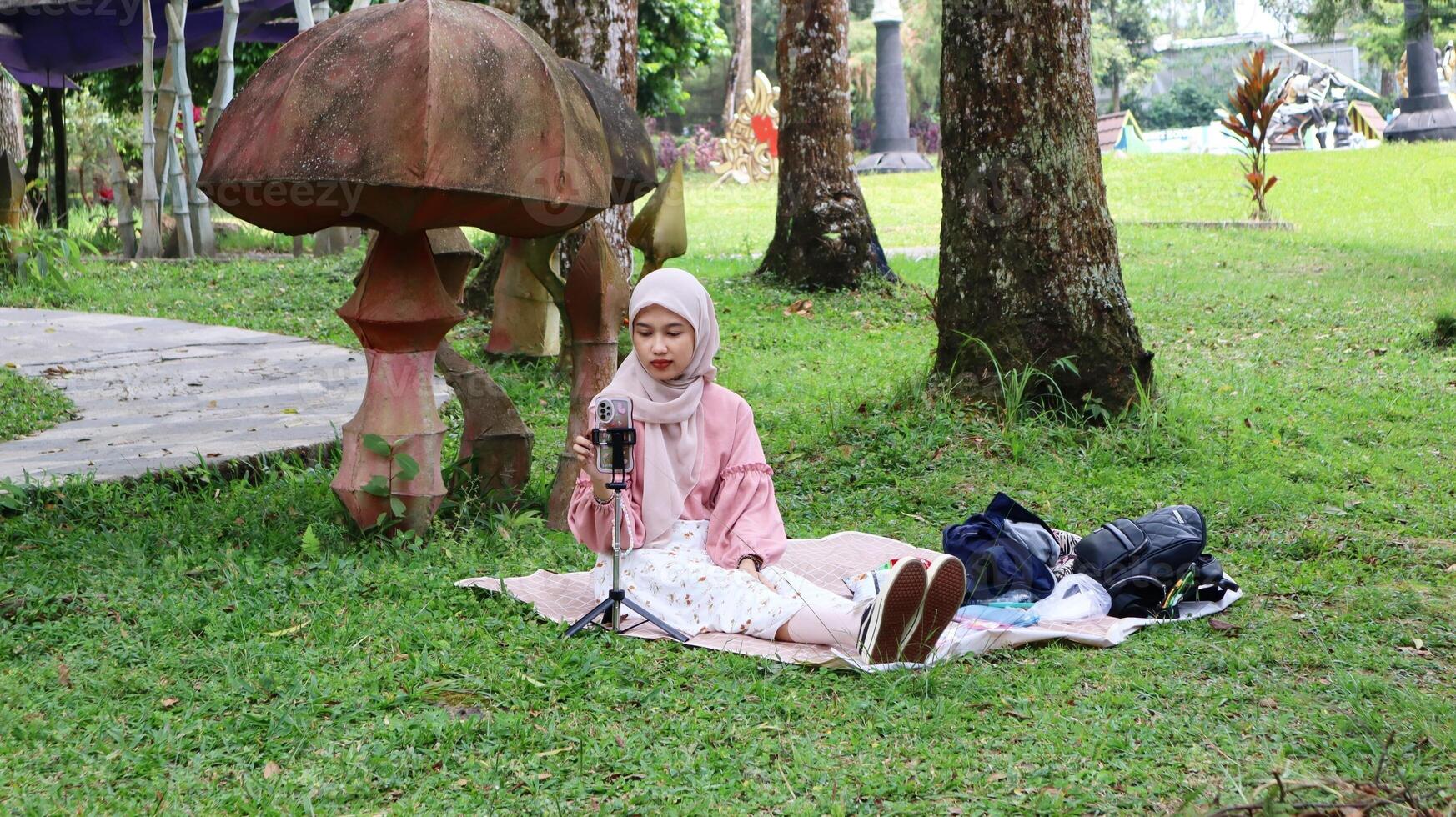 Asian Muslim girls are holding a photo session with a picnic and rustic theme in a warm park