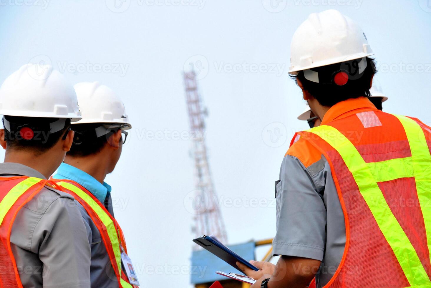 Construction workers are supervising the project at site and wearing safety helmets photo
