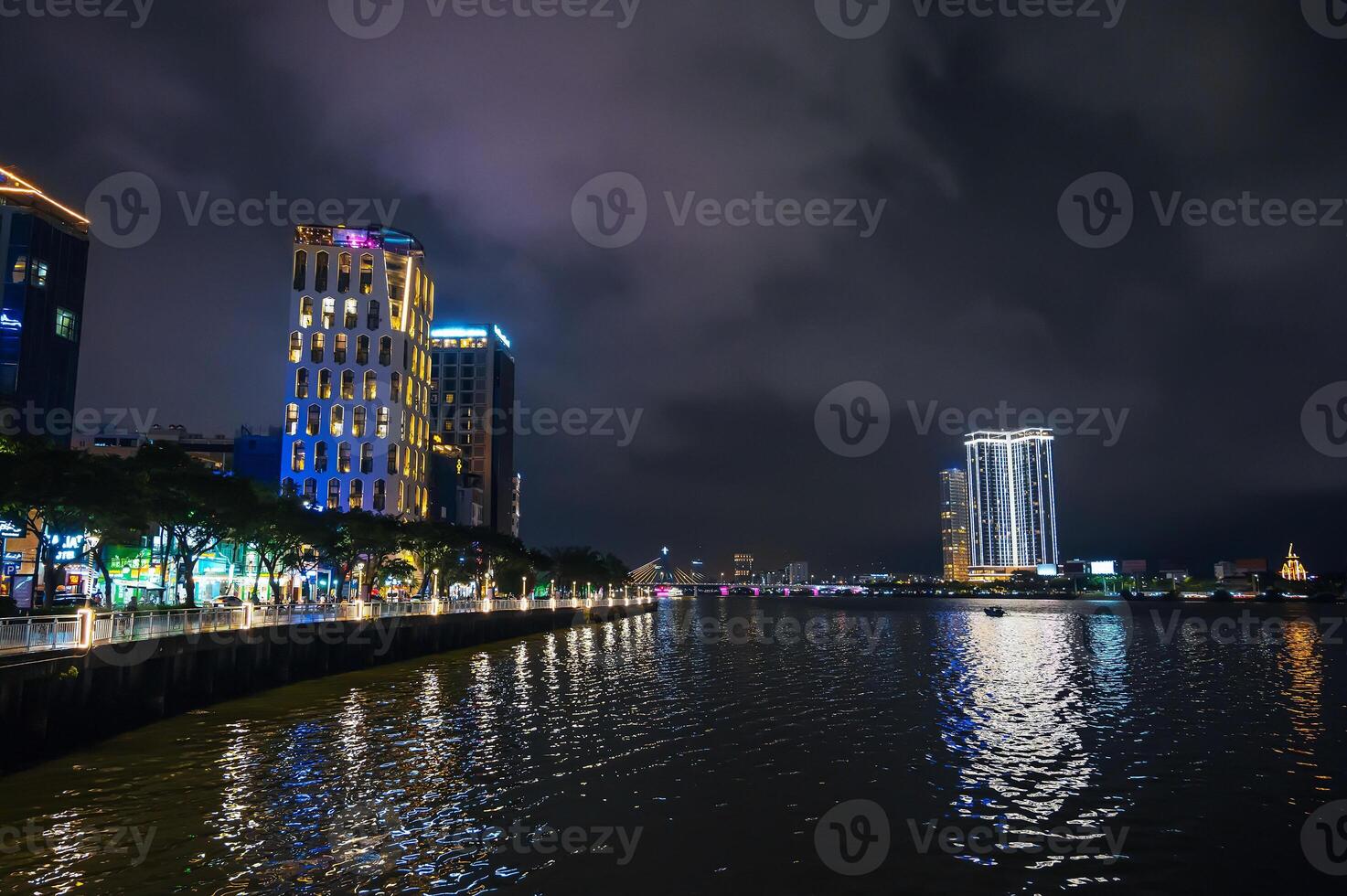 Da Nang city with a Han River Bridge over the Han river and skyscrapers hotels in Vietnam at night photo