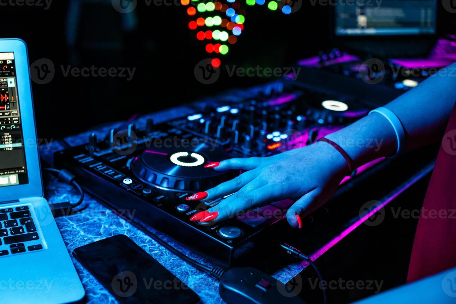 girl DJ mixes music with her hands on a music mixer in a night club at a party photo