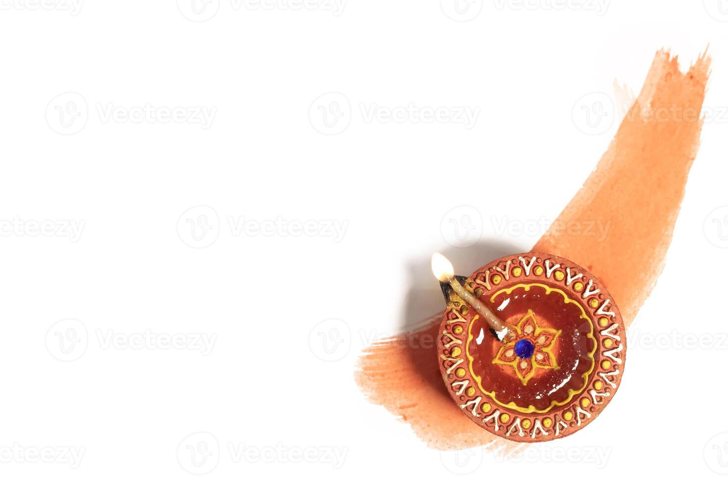 Hindu tradition Diwali diya oil lamps burning over paint stroke on white background. photo