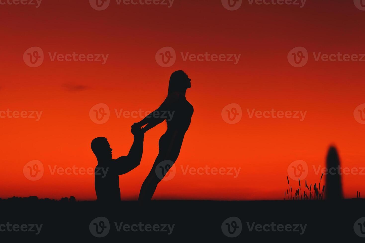 couple of people jointly perform a stretching and balance exercise in a yoga pose photo