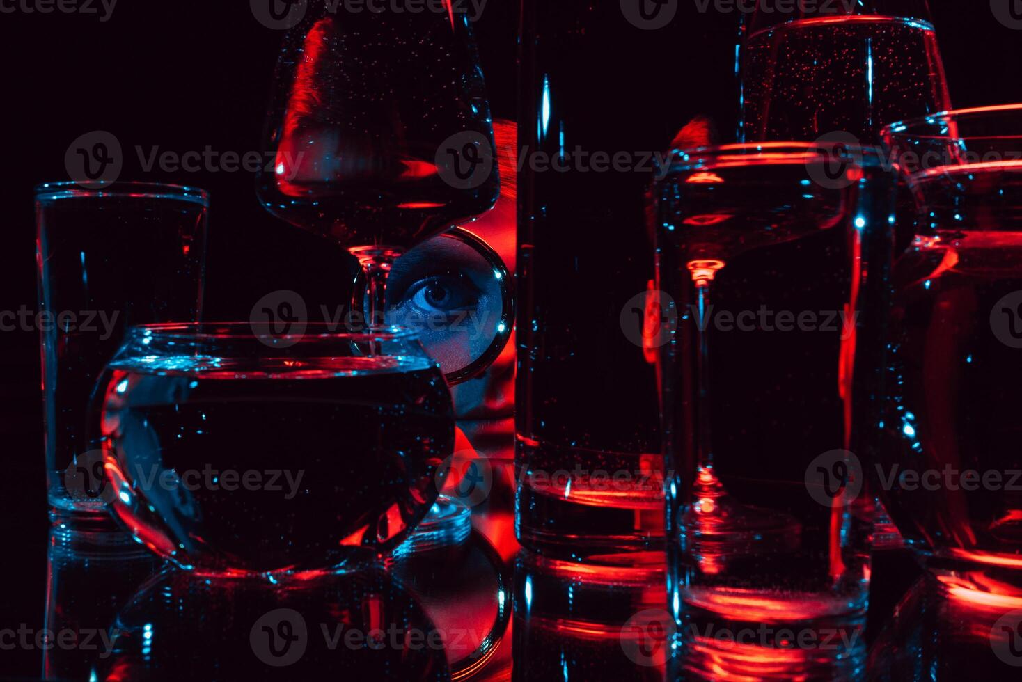 portrait of a strange man looking through a magnifying glass and glass glasses with water photo