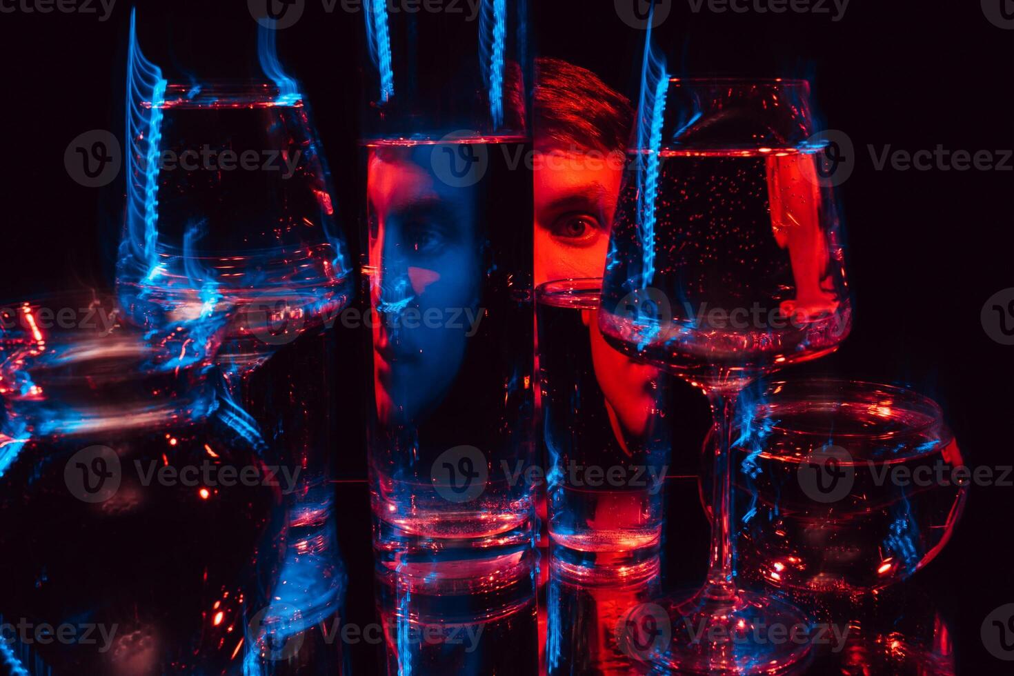 strange man looking through glasses of water with blurring photo