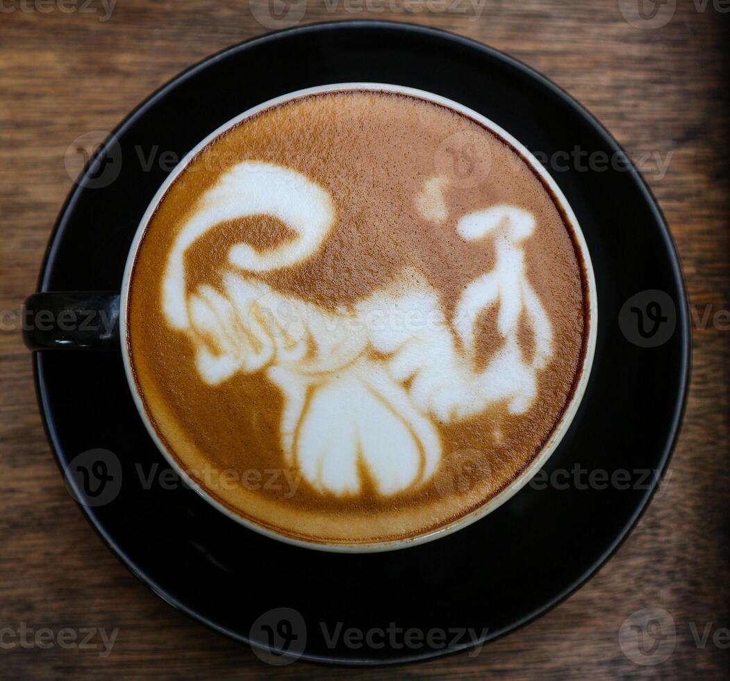 Close up black coffee cup with latte art on wood tab photo