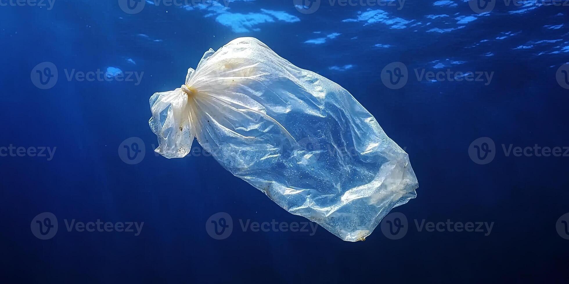 A single plastic bag floats in the blue ocean, a stark reminder of pollution. photo