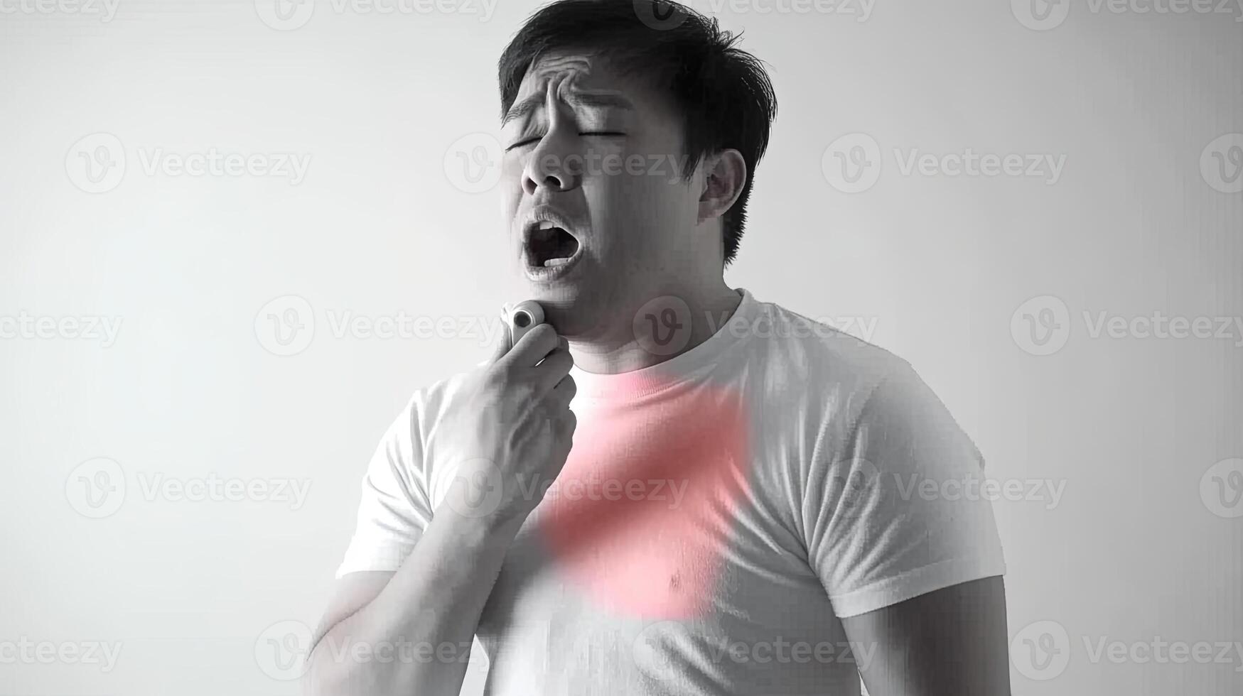 A man with a sore throat, coughing and holding his chest. He is in pain and suffering. photo