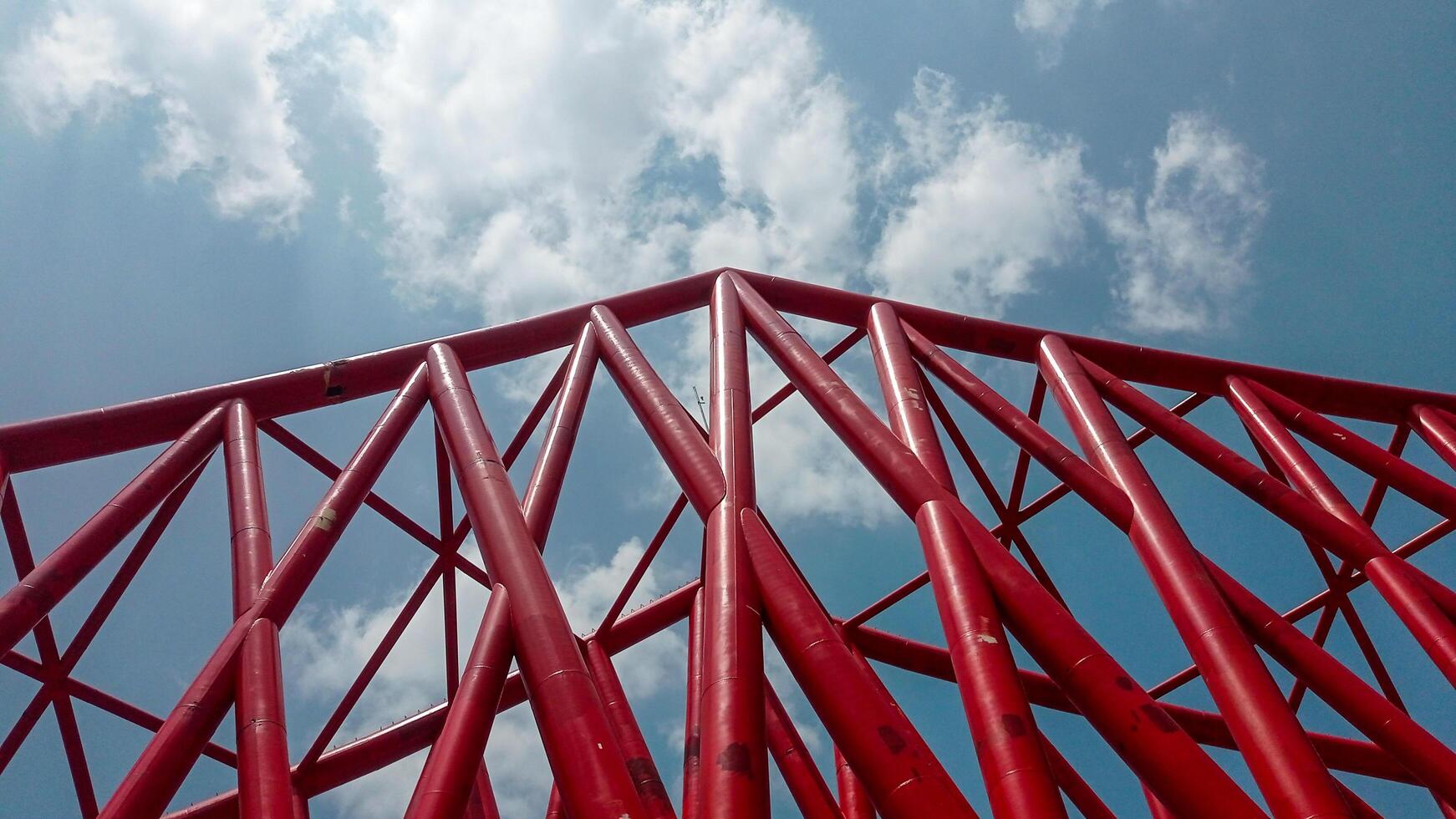 construction of the Indonesian railway bridge. a red structure with a blue sky and clouds photo