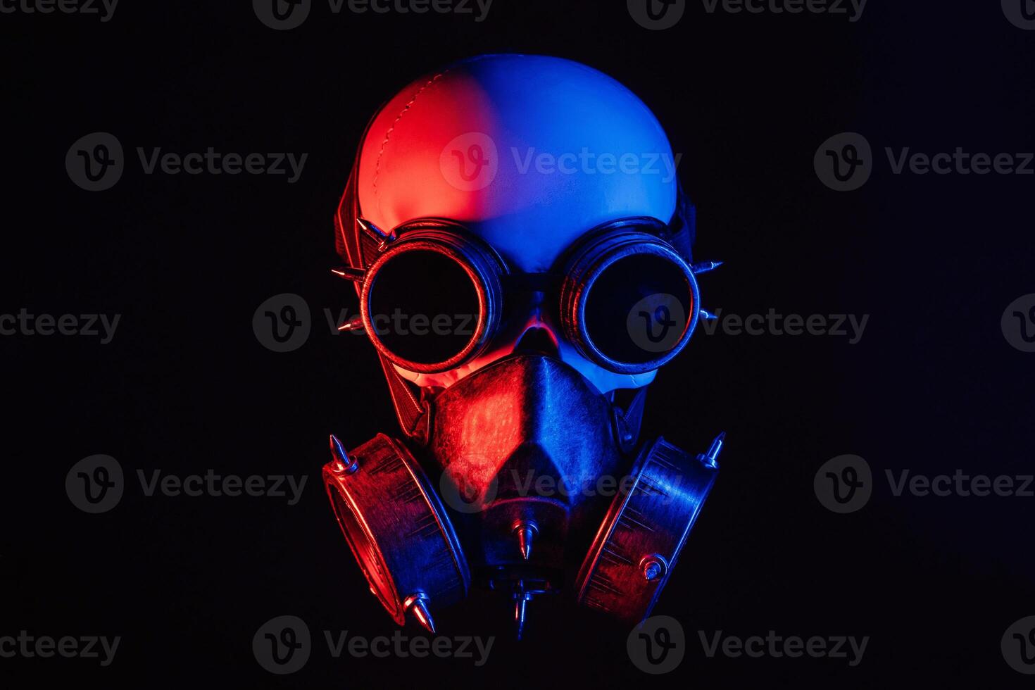 human skull in steampunk glasses and a gas mask with red and blue neon light photo