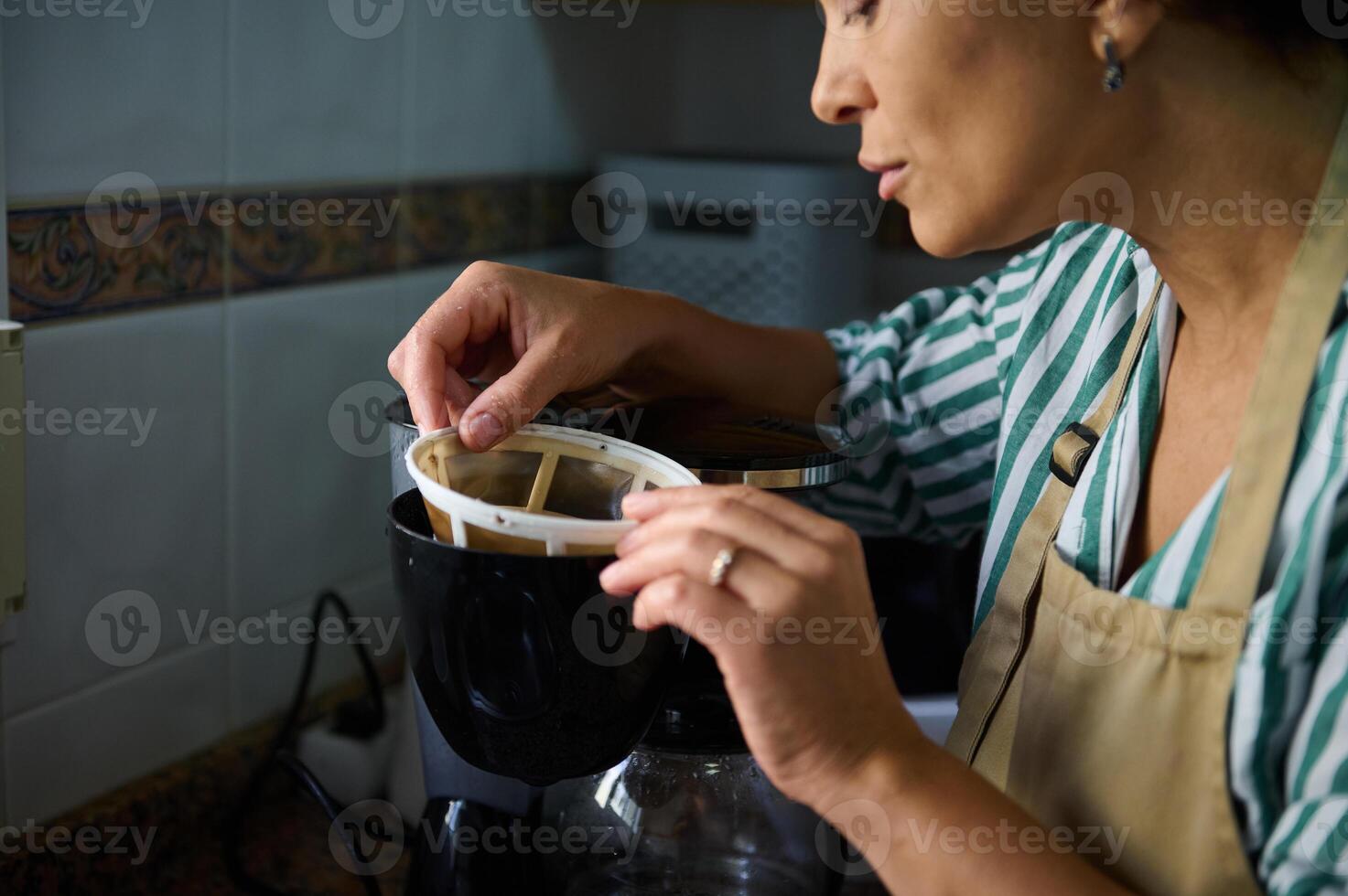 Woman preparing coffee with a drip coffee machine in the kitchen photo