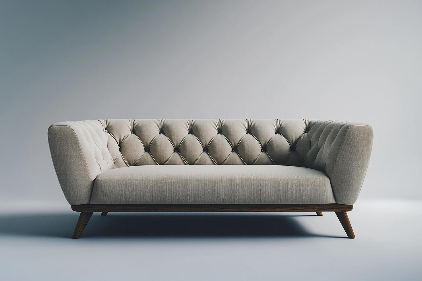 Chic modern sofa with button tufts and angular wooden legs isolated photo