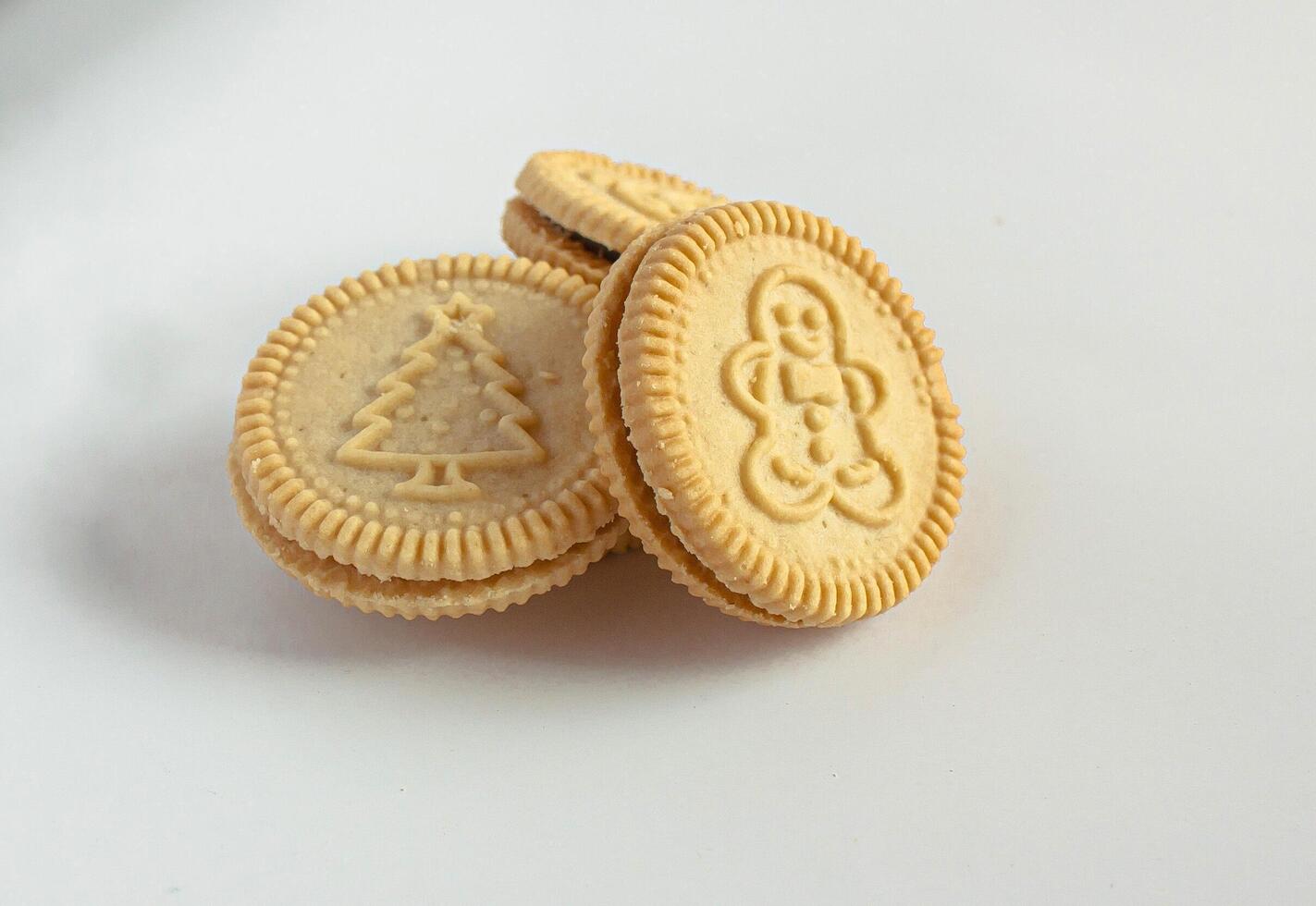 Round cookies with including Christmas symbols such as trees, snowmen and other holiday characters. Vanilla or butter sandwich cookies. photo