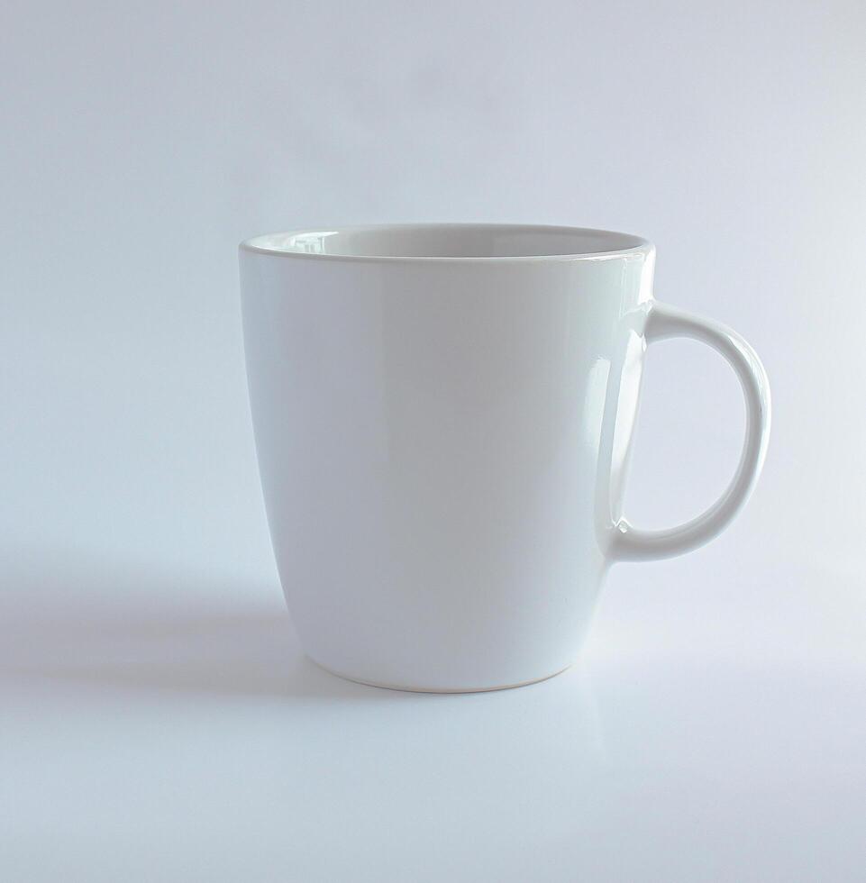 plain white ceramic mug with a simple handle. It has a clean and minimalistic design, perfect for enjoying coffee, tea, or any other hot beverage. photo