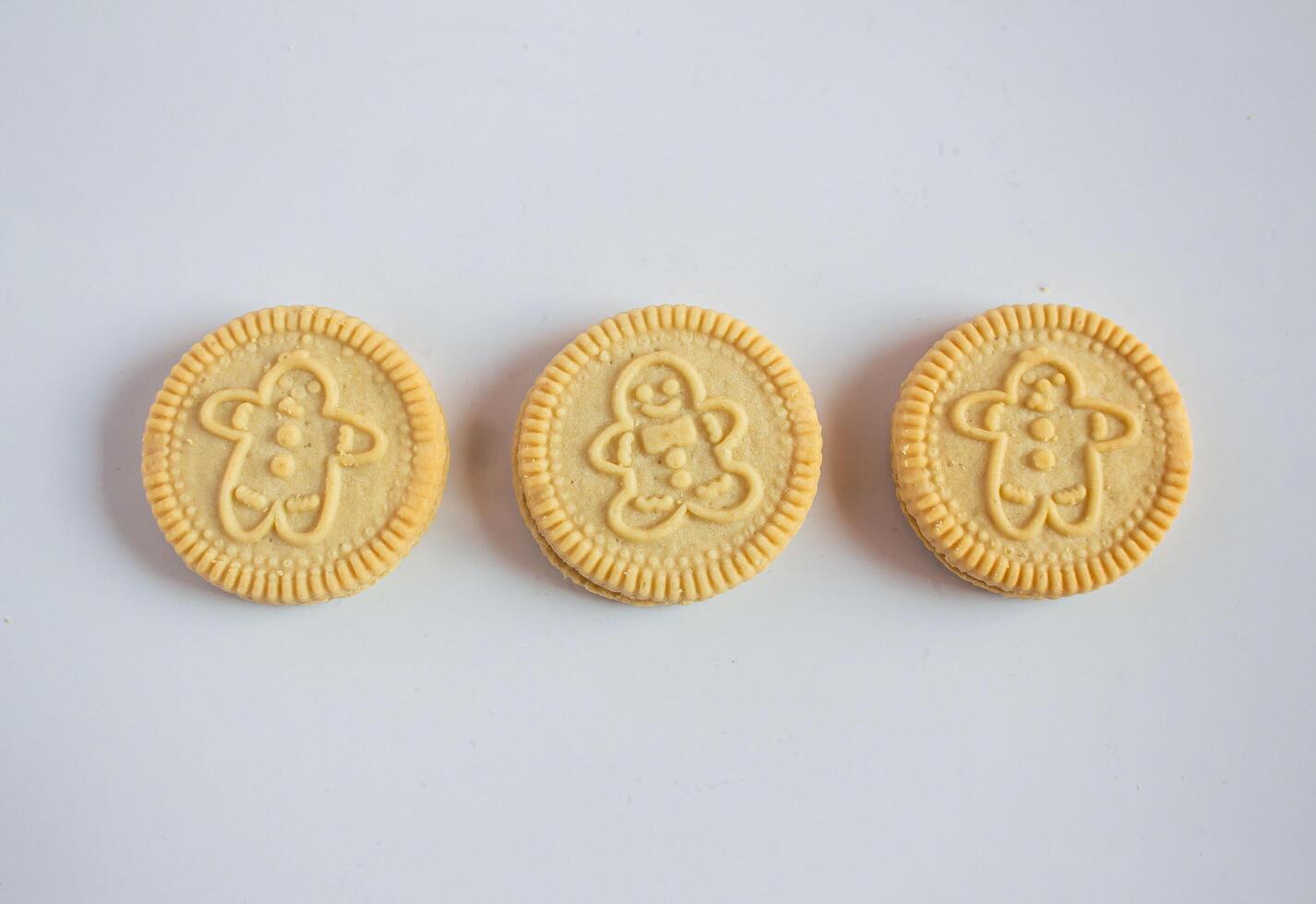 Round cookies with including Christmas symbols such as trees, snowmen and other holiday characters. Vanilla or butter sandwich cookies. photo