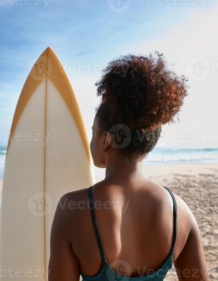 portrait of a black female surfer with her back in the foreground and the beach in the background photo