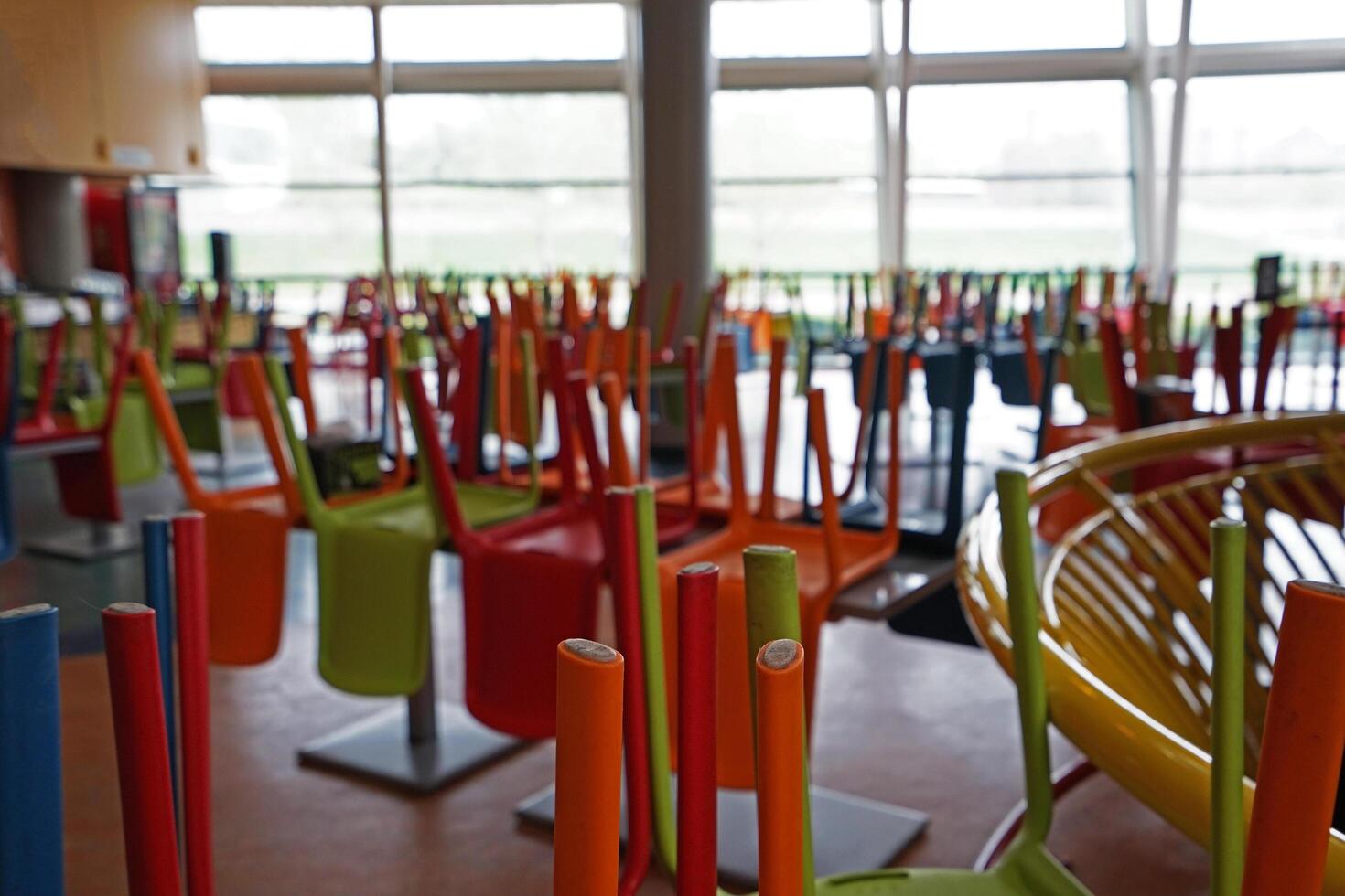 Colorful chairs were lifted on tables photo