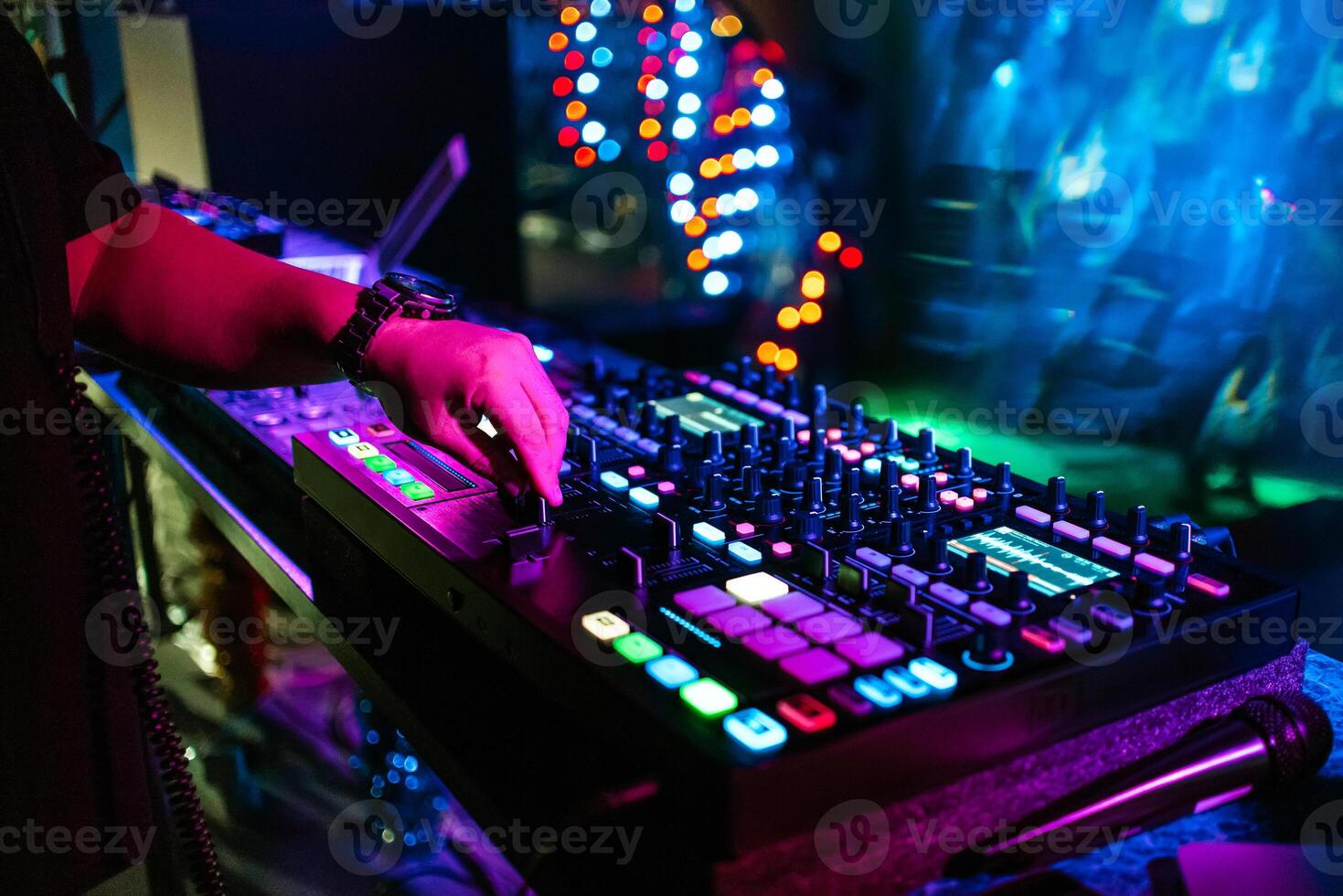 male DJ mixes electronic music on a professional music controller photo