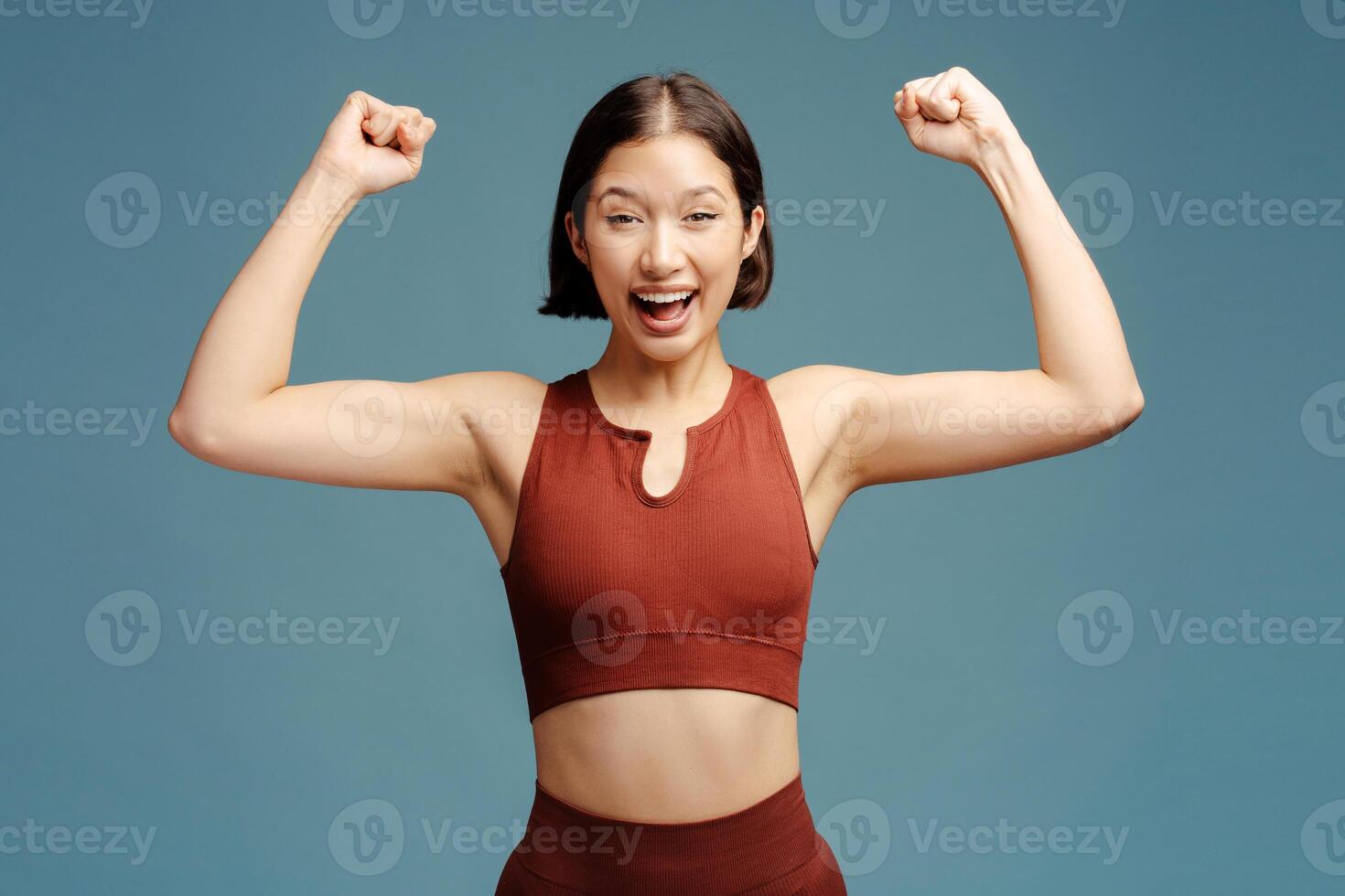 Portrait of excited brunette woman rejoicing isolated on blue background photo