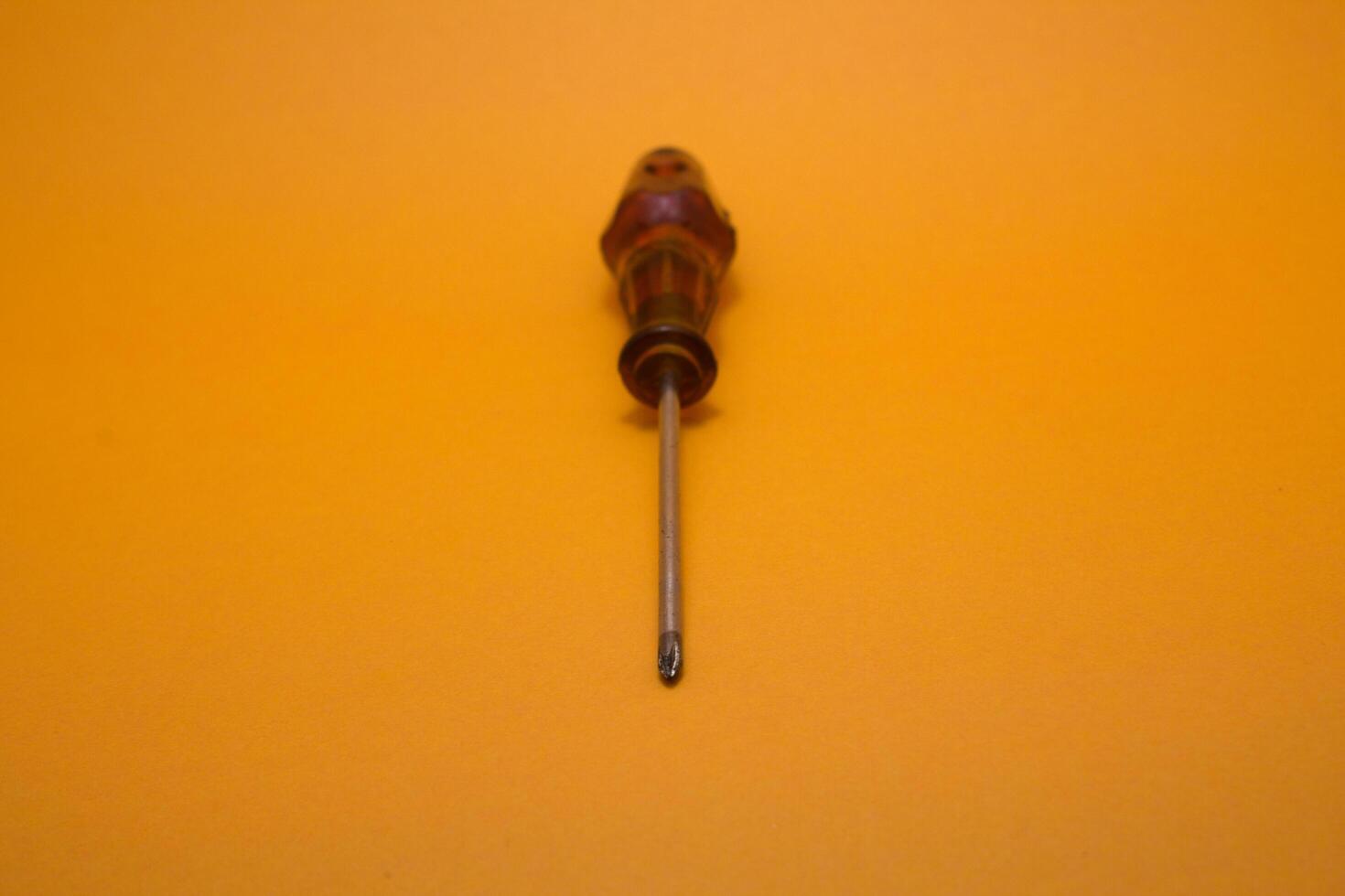 a red handle screwdriver isolated on yellow background photo