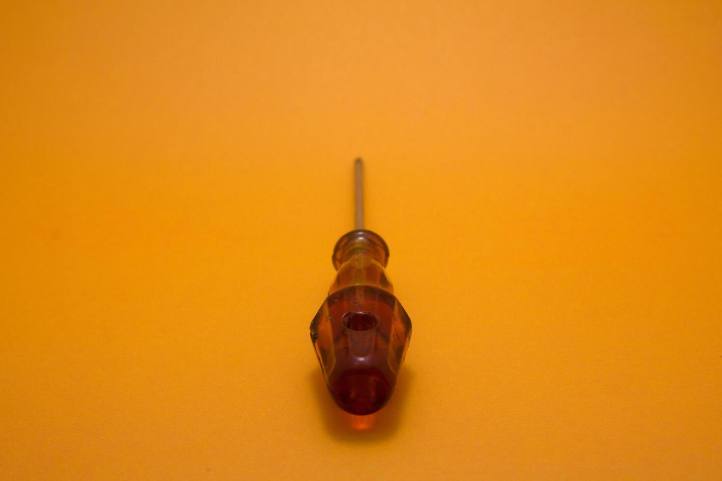 a red handle screwdriver isolated on yellow background photo