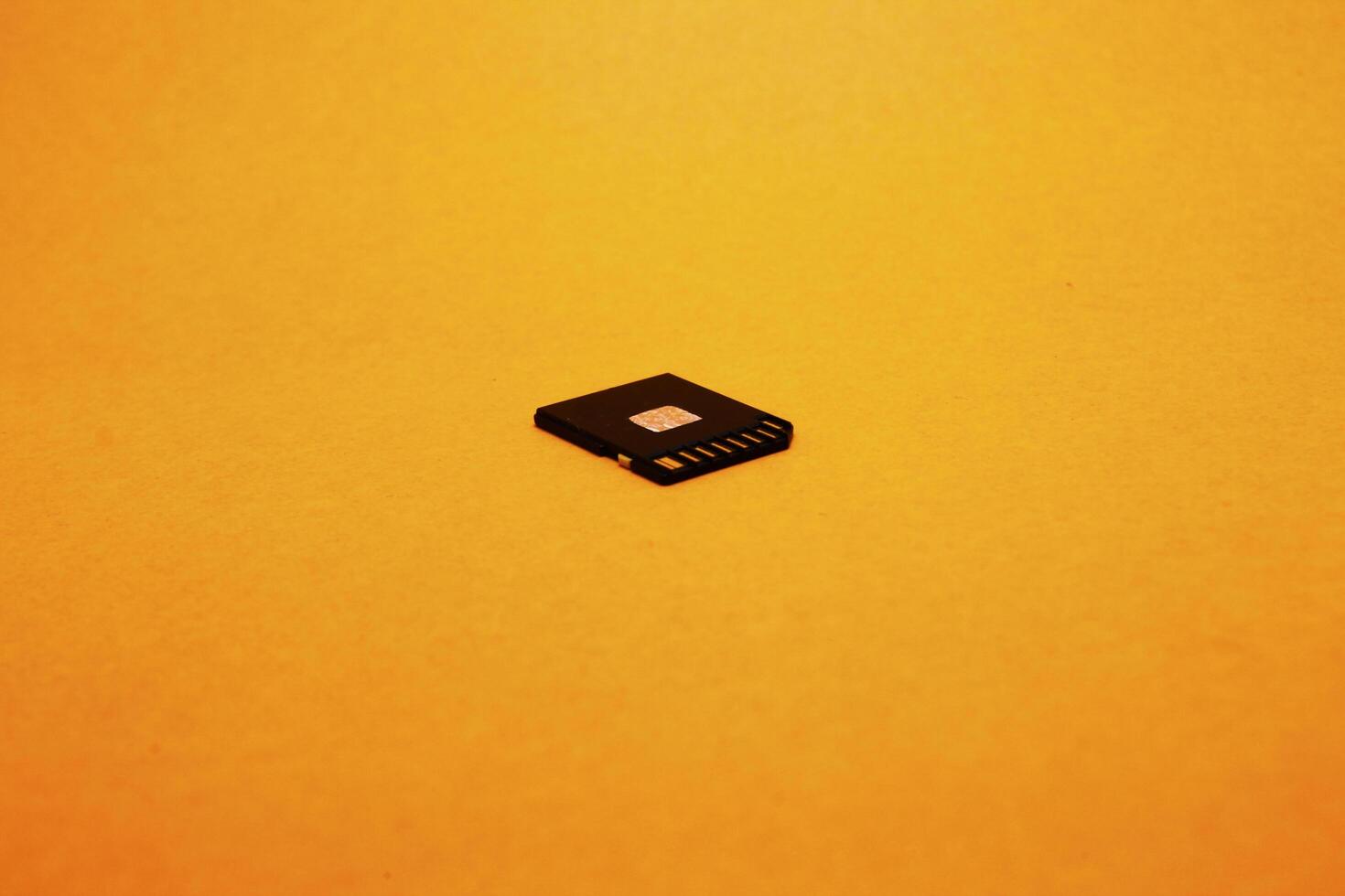 Black SD memory card isolated on yellow background photo