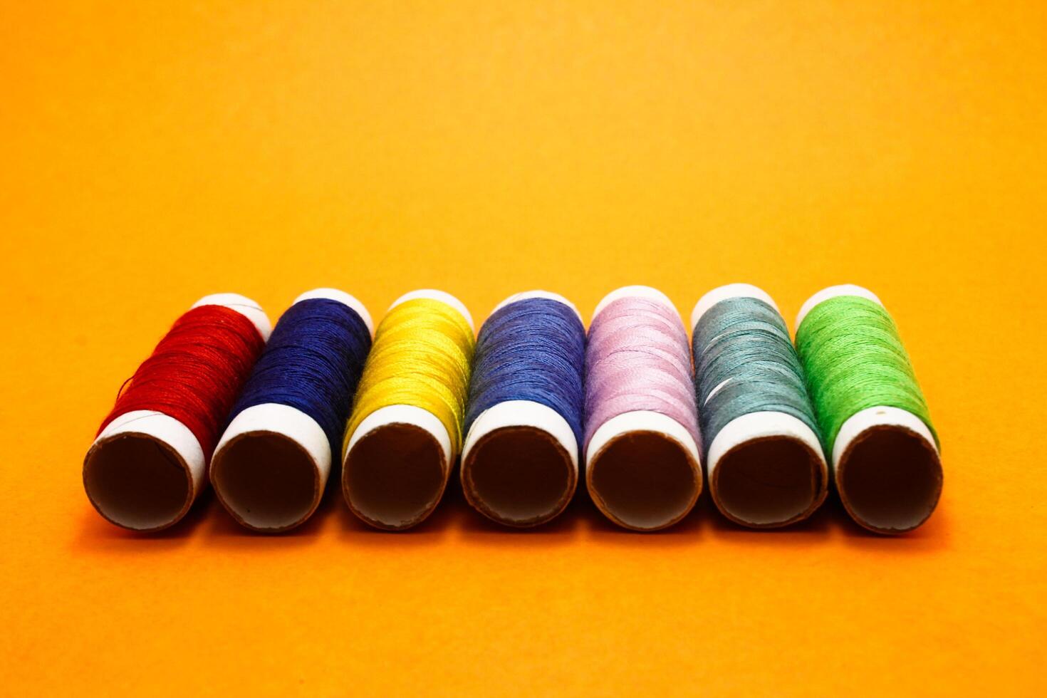 sewing thread roll isolated on yellow background photo